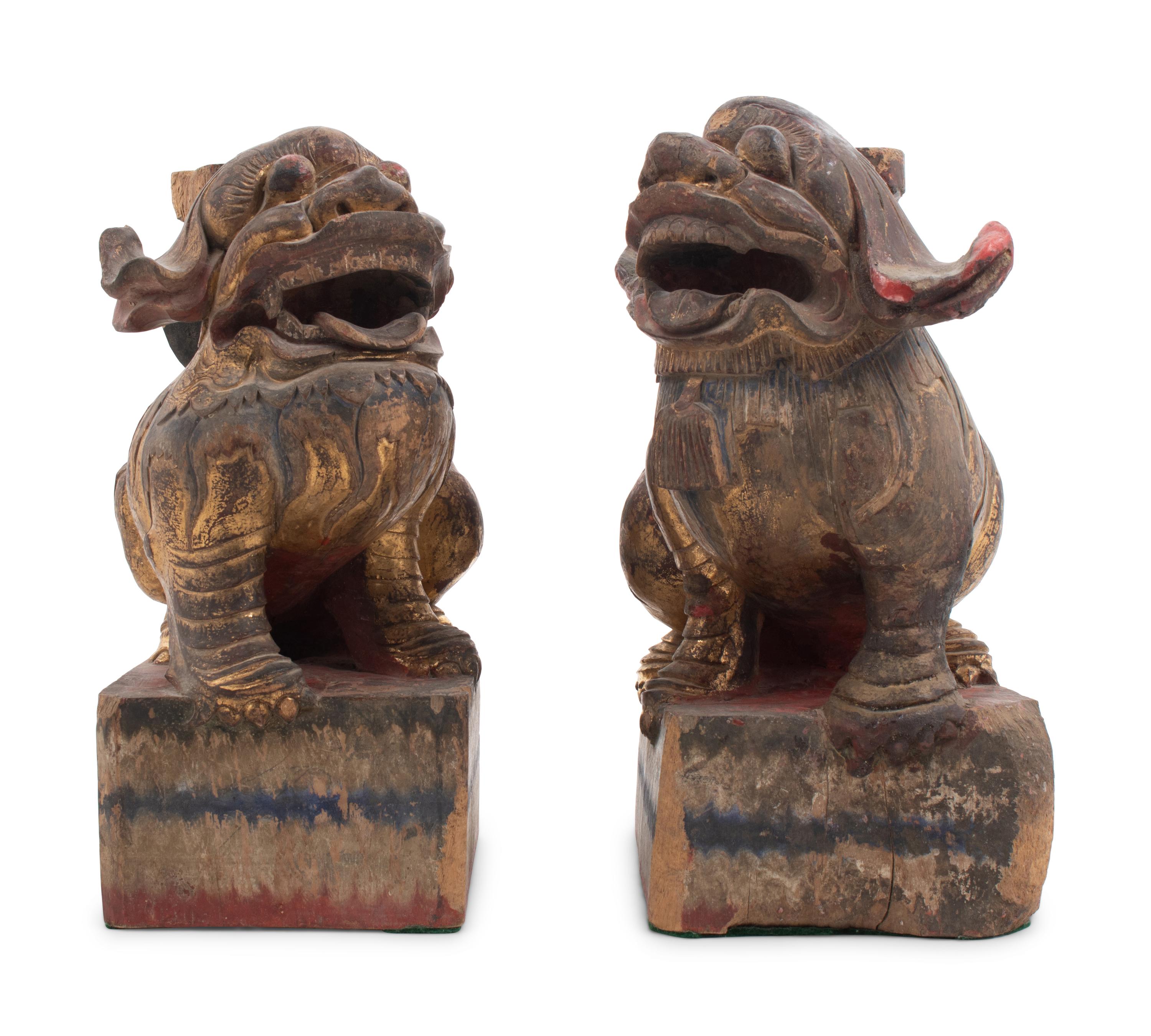 A Pair of Chinese Giltwood Candlesticks with Buddhistic Lions