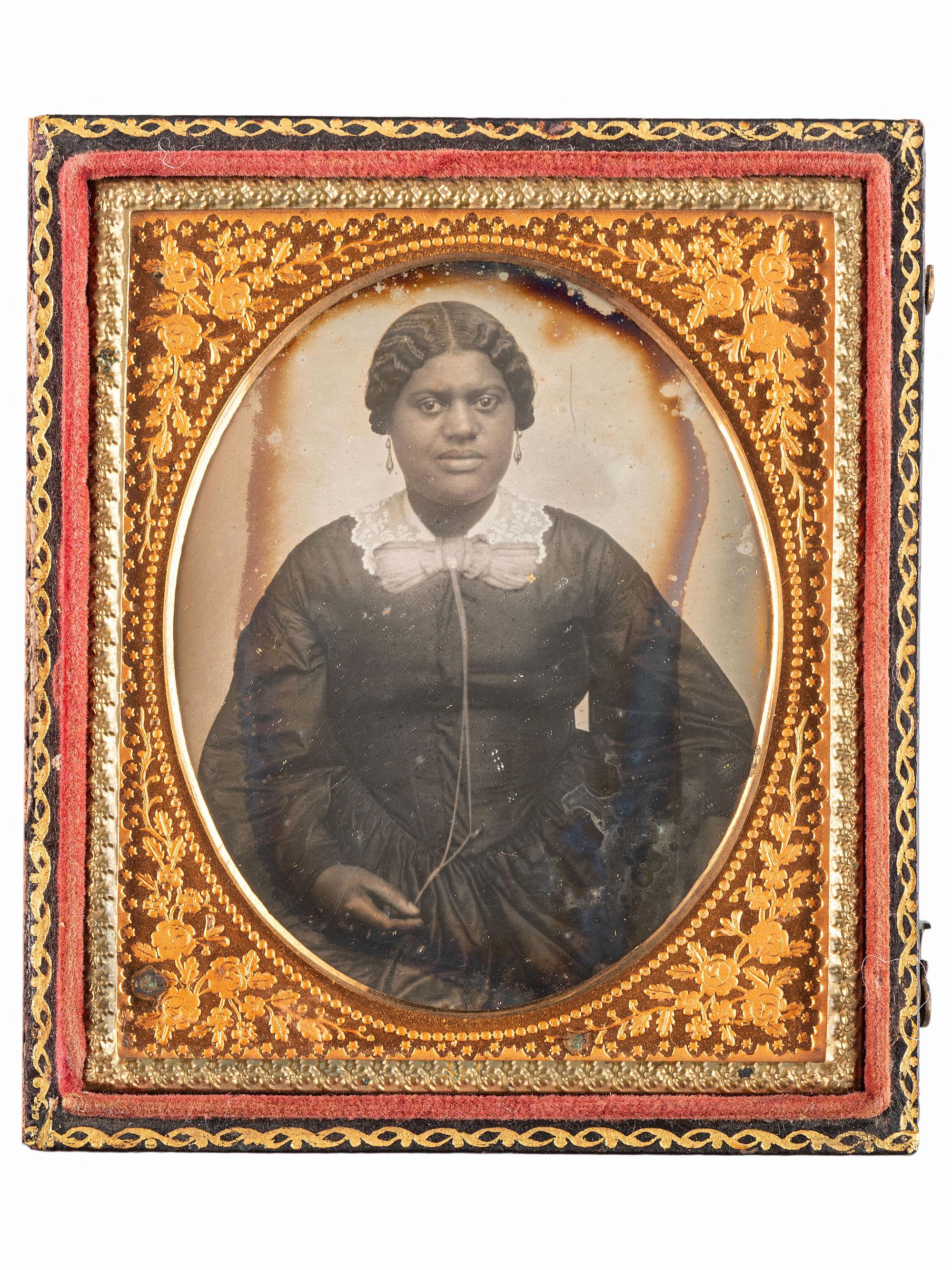 [EARLY PHOTOGRAPHY-AFRICAN AMERICANA]. Sixth plate daguerreotype portrait of subject identified as "Grandma Binx" with braided hairwork heart.