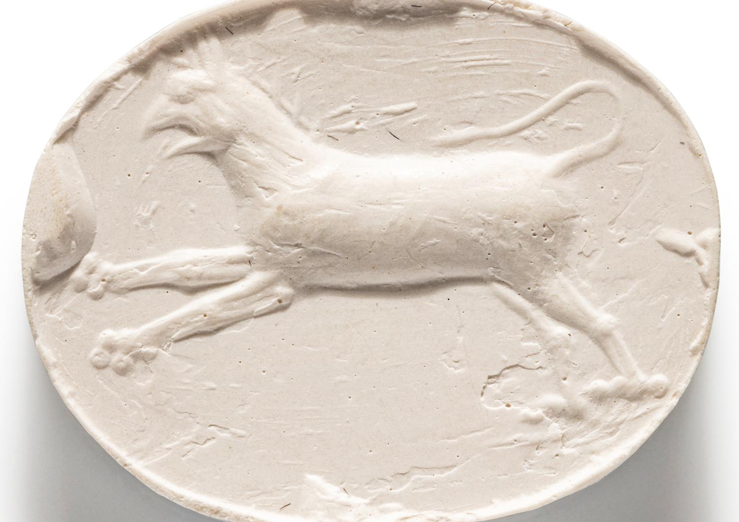 A Greco-Persian Blue Chalcedony Scaraboid with a Leaping Griffin