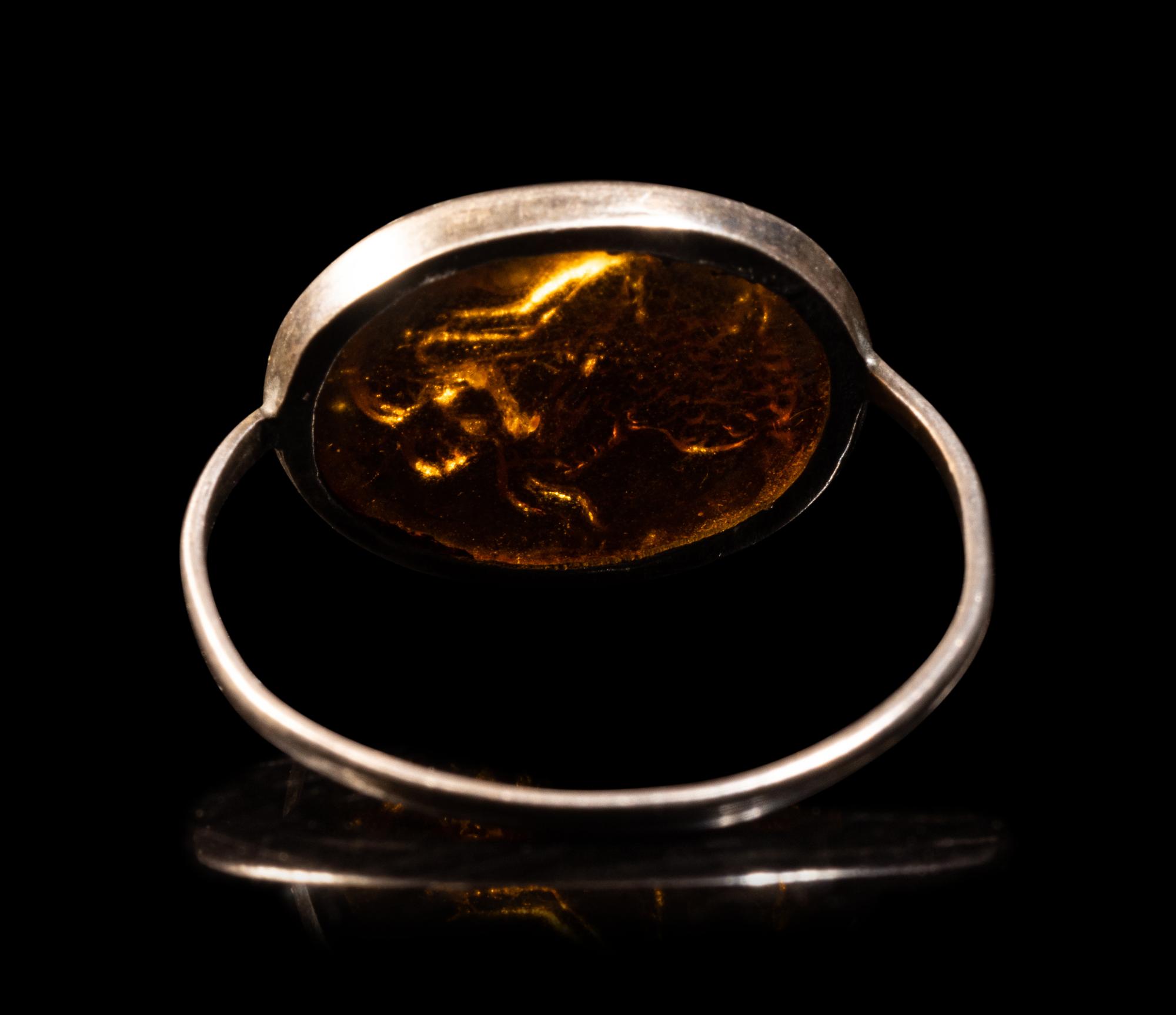 A Roman Silver and Glass Finger Ring of a Satyr Kissing a Goat