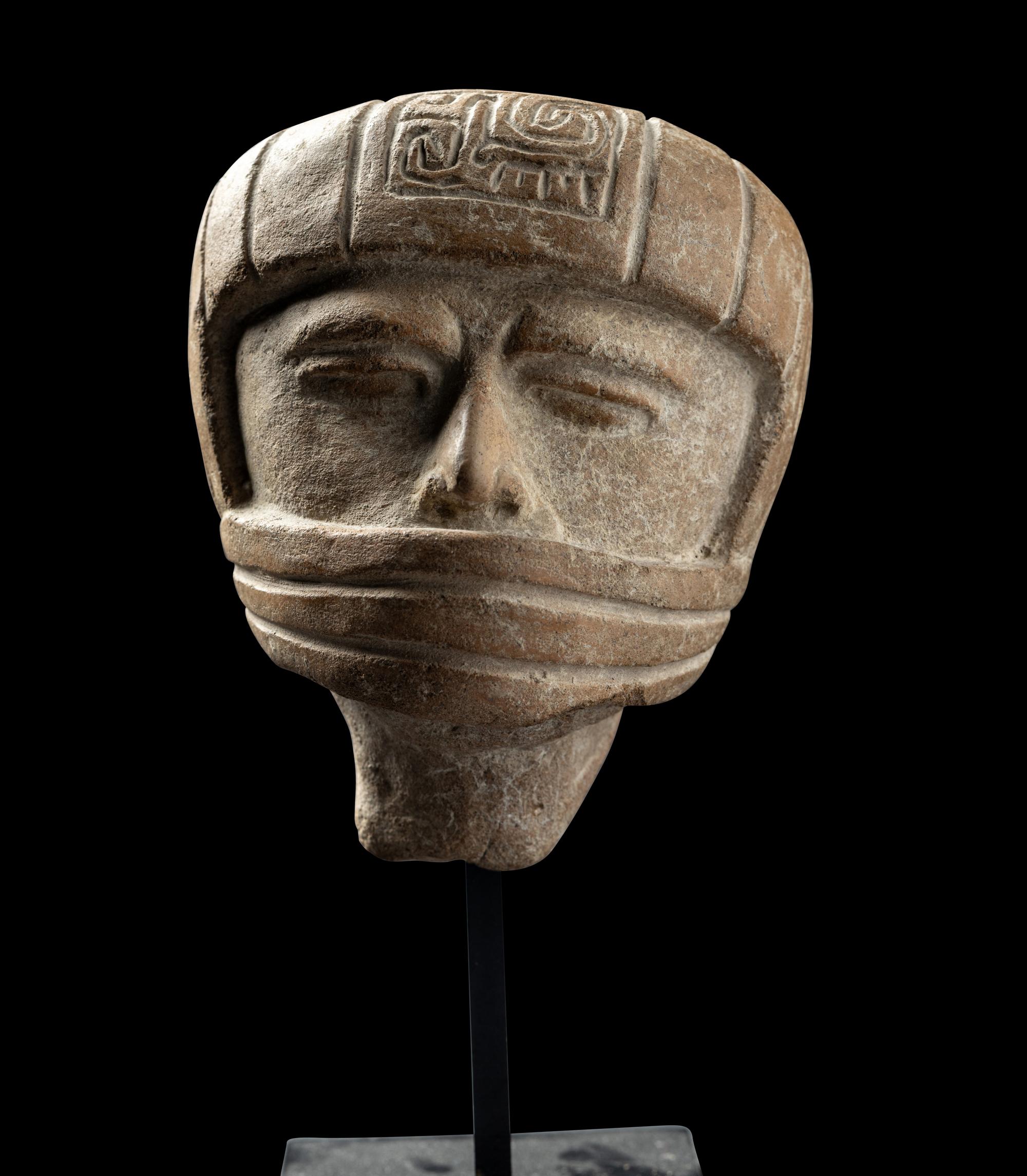 A Veracruz Terracotta Head Wearing a Helmet with an Incised Glyph