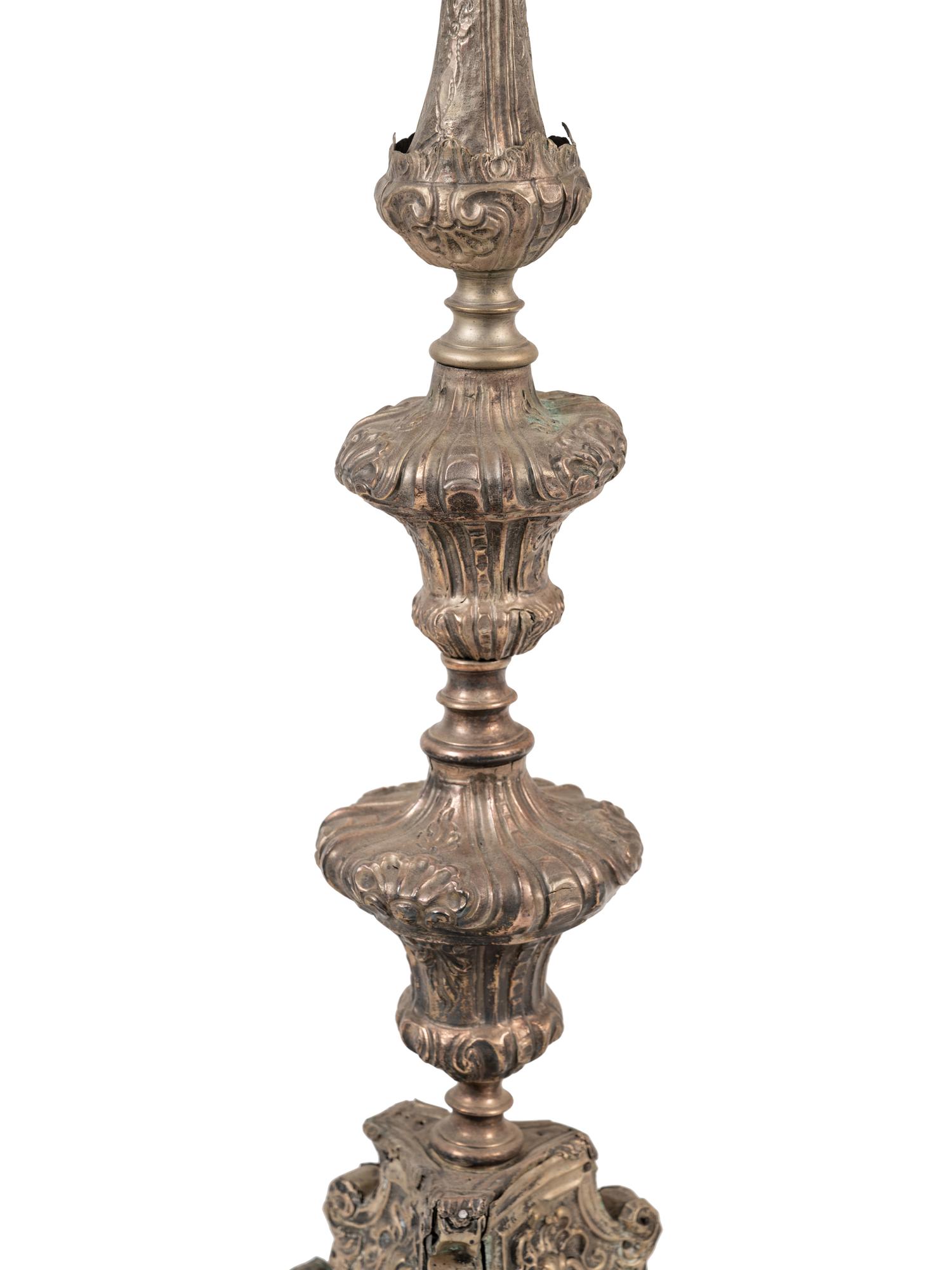 A Pair of Baroque Repoussé Decorated Silvered Metal Pricket Sticks