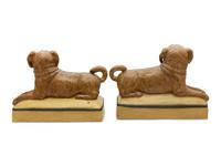 A Pair of Continental Ceramic Figures of Recumbent Pugs