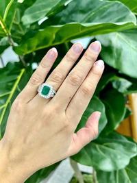 An emerald, diamond, and white gold ring