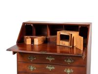 A Chippendale Carved and Figured Mahogany Reverse-Serpentine Claw-and-Ball Foot Slant-Front Desk