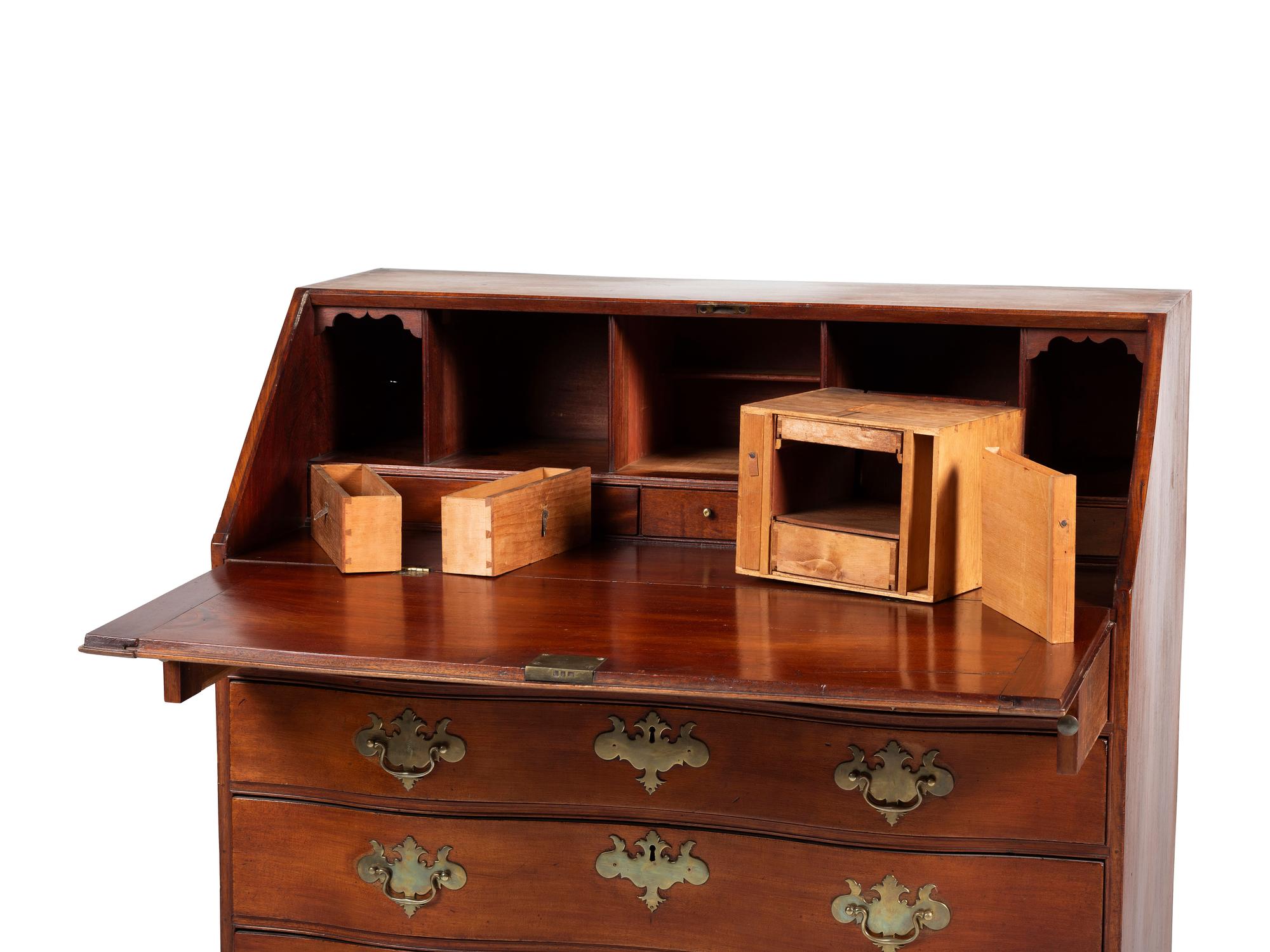 A Chippendale Carved and Figured Mahogany Reverse-Serpentine Claw-and-Ball Foot Slant-Front Desk