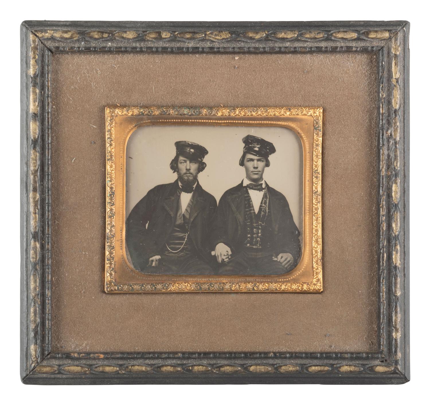 [EARLY PHOTOGRAPHY]. Occupational ambrotype of two men holding hands, possibly railroad conductors.
