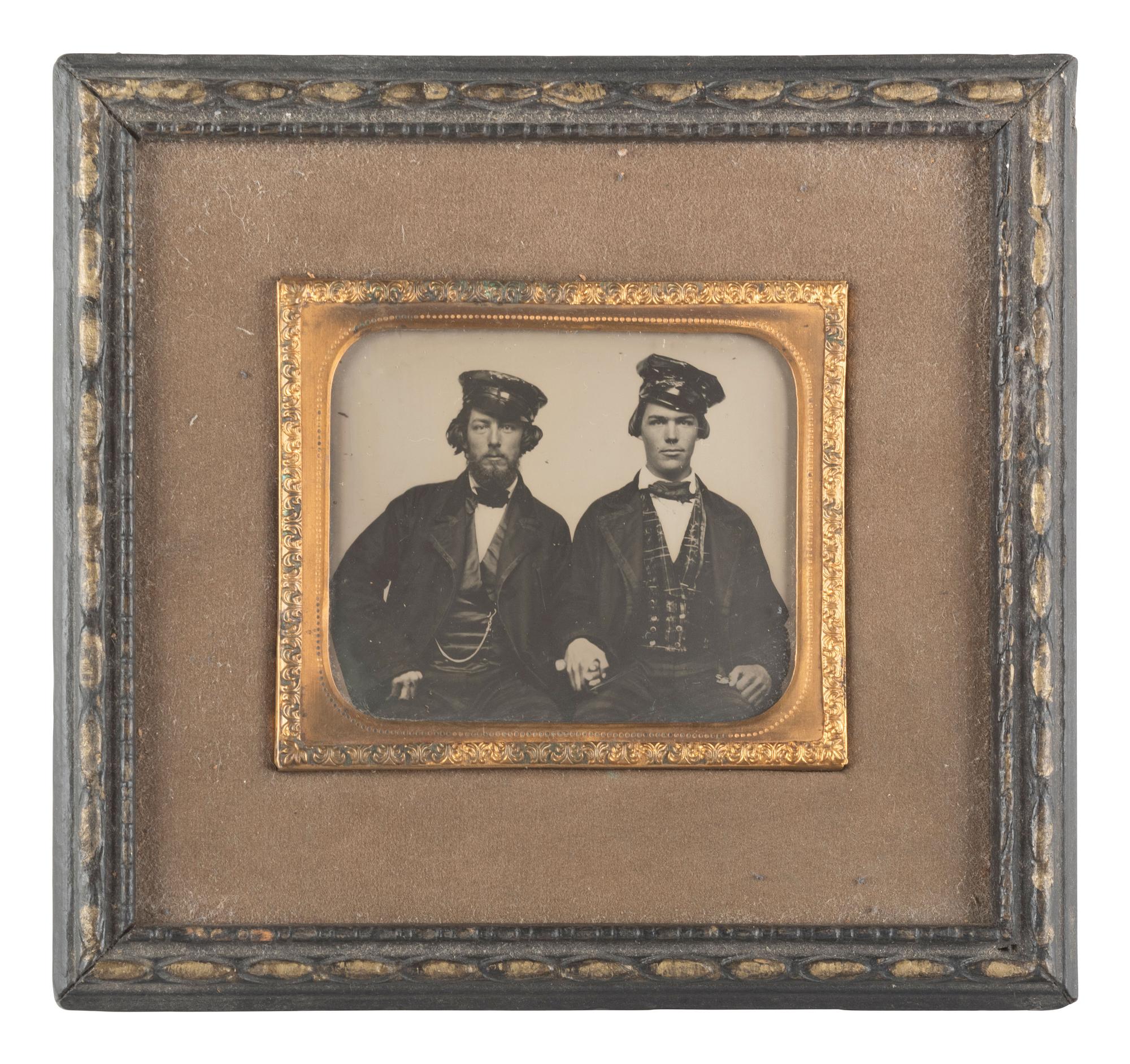 [EARLY PHOTOGRAPHY]. Occupational ambrotype of two men holding hands, possibly railroad conductors.