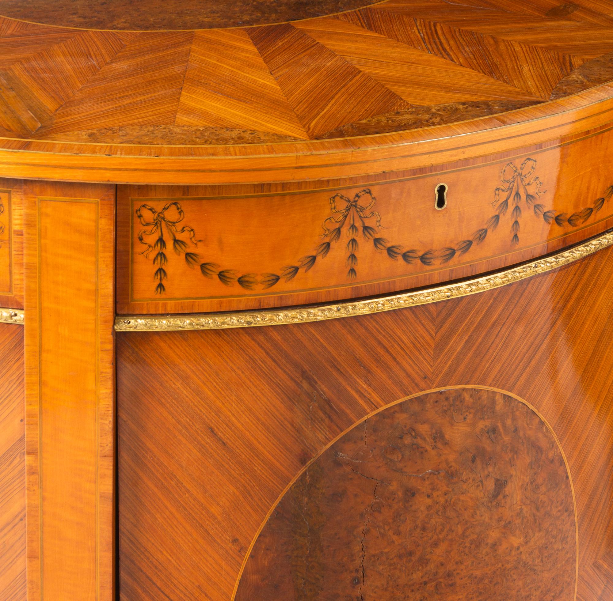 A Pair of George III Gilt Bronze Mounted Tulipwood, Burr Yew and Satinwood Marquetry Demilune Cabinets