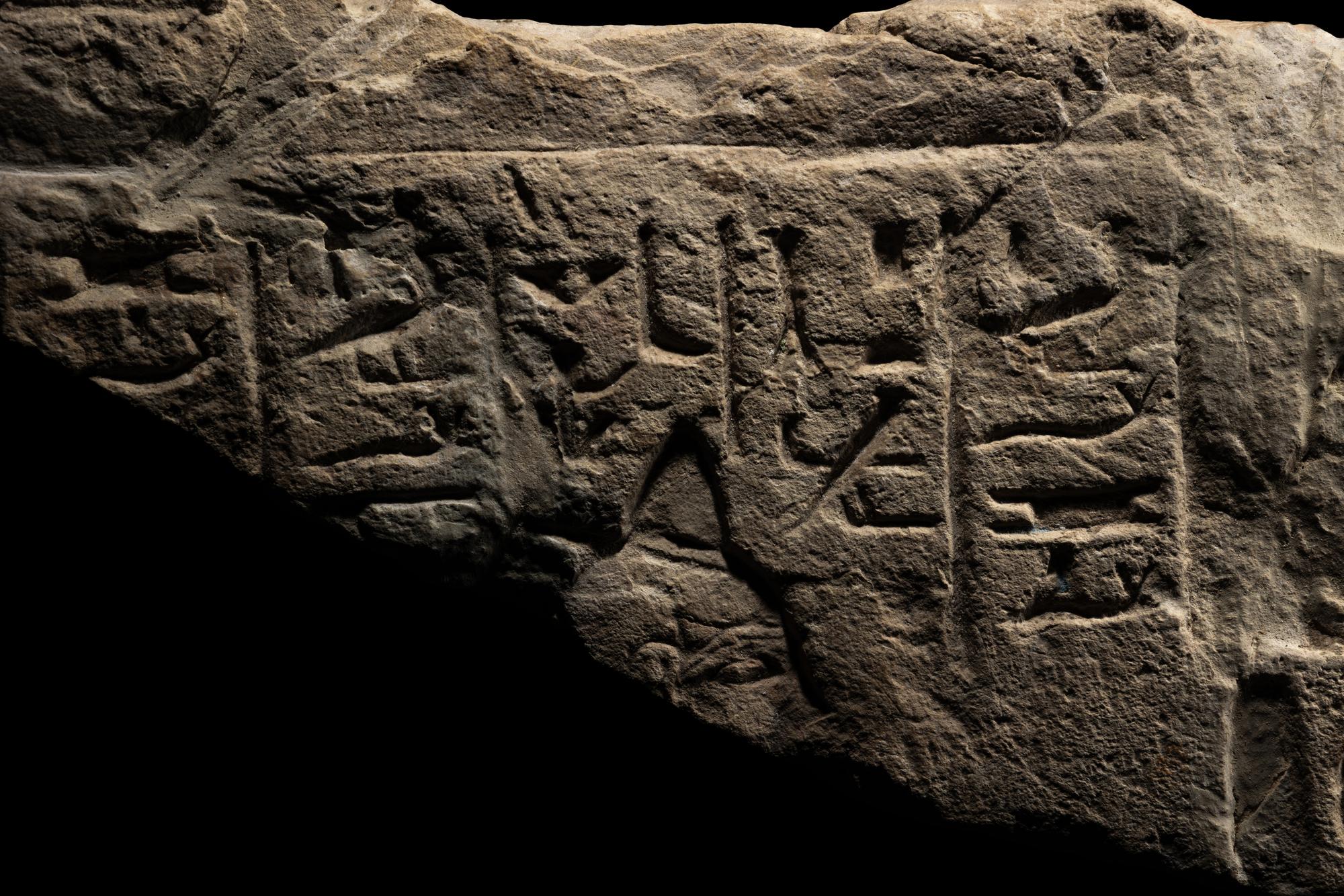 An Egyptian Limestone Relief Fragment Depicting an Attendant Wearing a Head-Cone