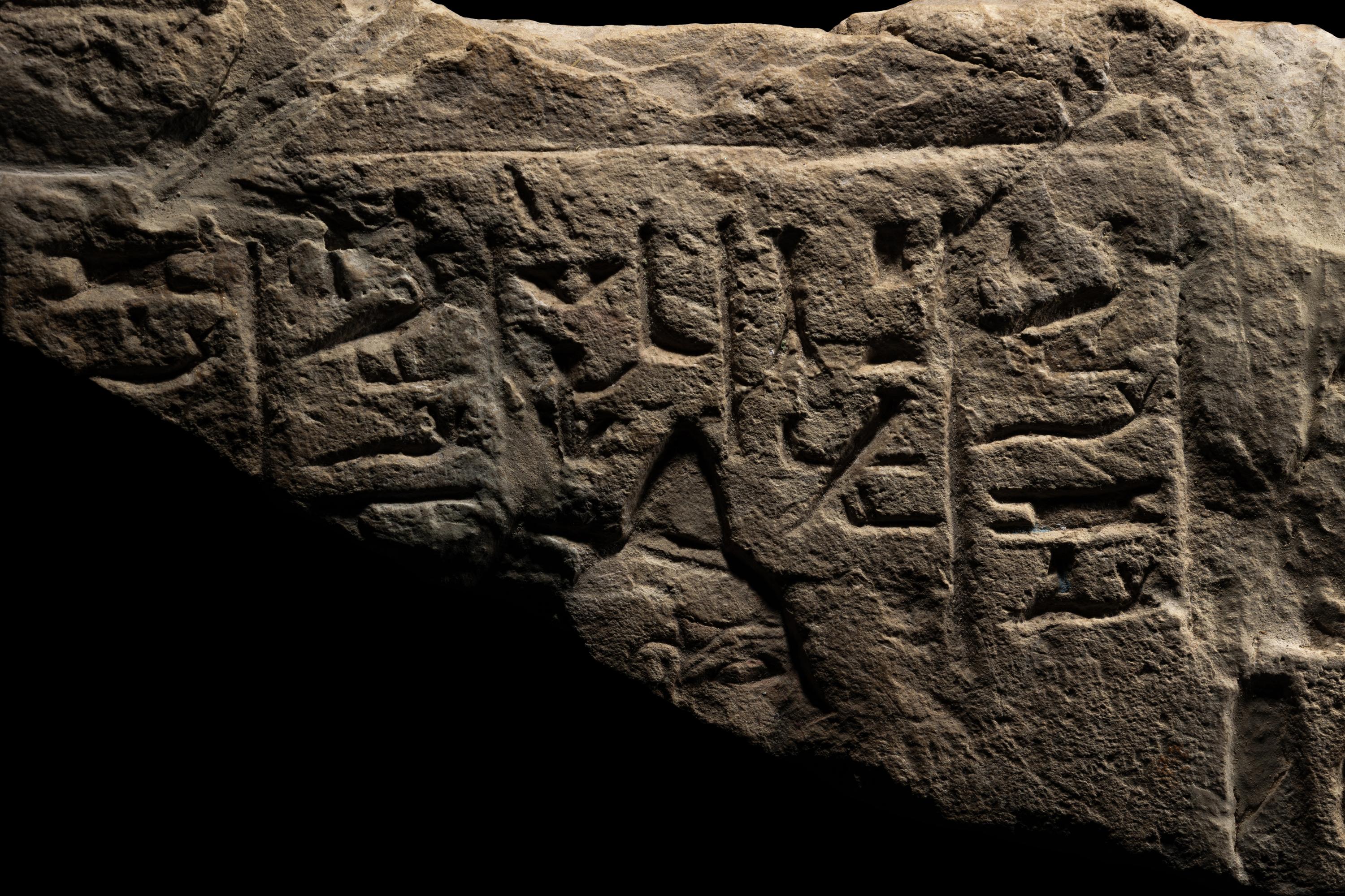 An Egyptian Limestone Relief Fragment Depicting an Attendant Wearing a Head-Cone