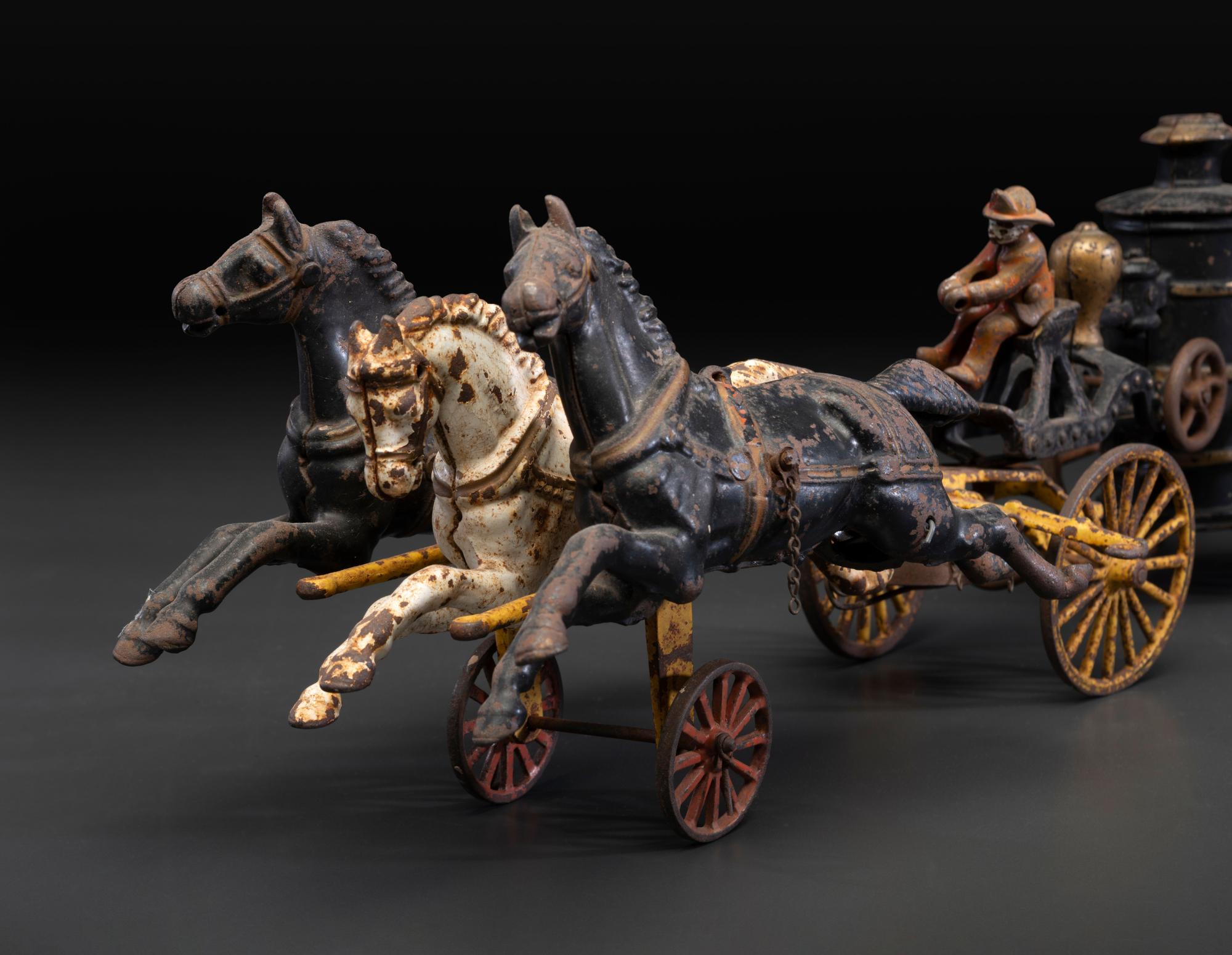 A Painted Cast Iron Three-Horse Fire Pump Wagon Toy