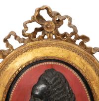 A Pair of Giltwood Framed Ebonized Relief Portrait Plaques of French Nobility, 18th Century