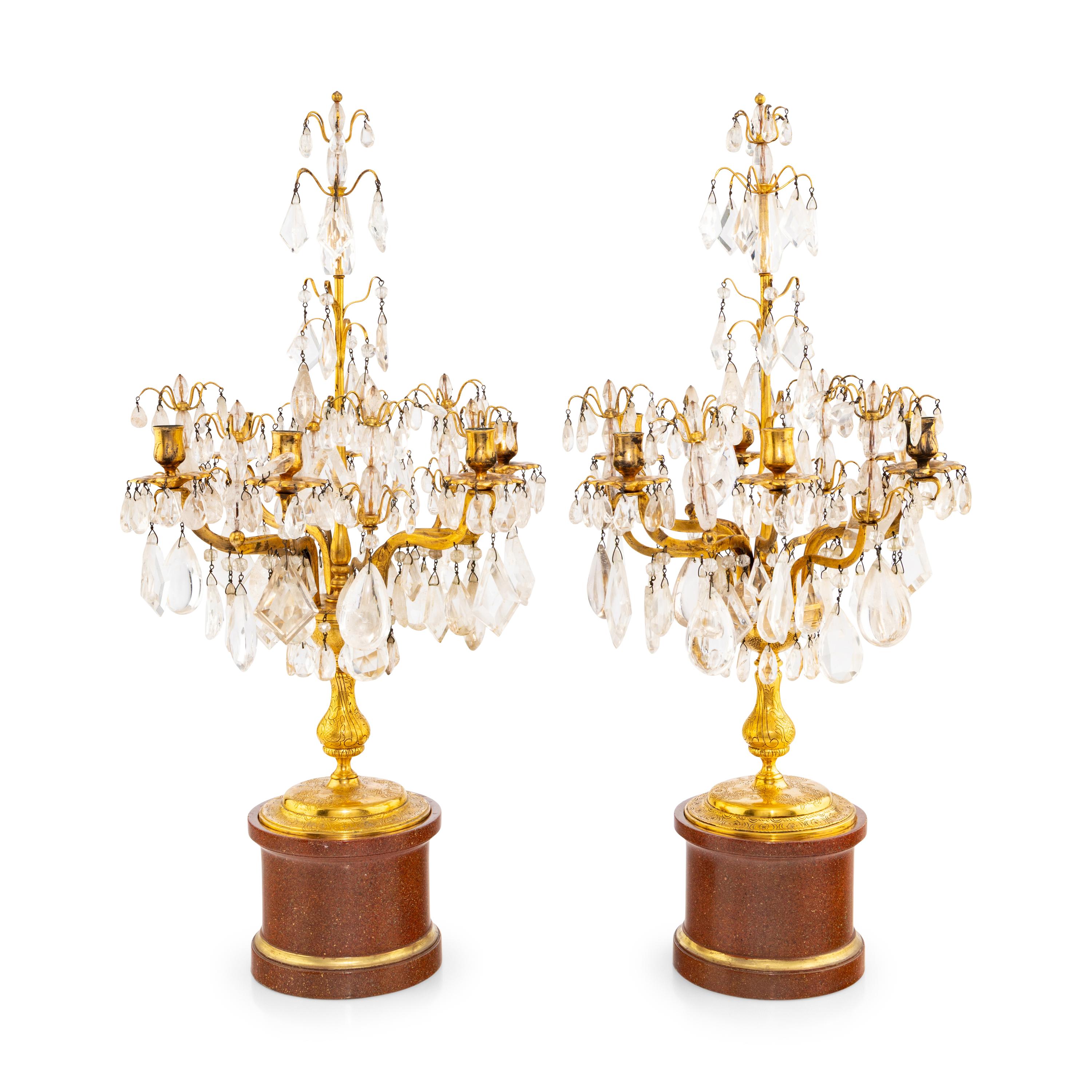 A Pair of Régence Style Rock Crystal, Cut Glass and Engraved Gilt Bronze Six-Light Candelabra on Simulated Porphyry Bases