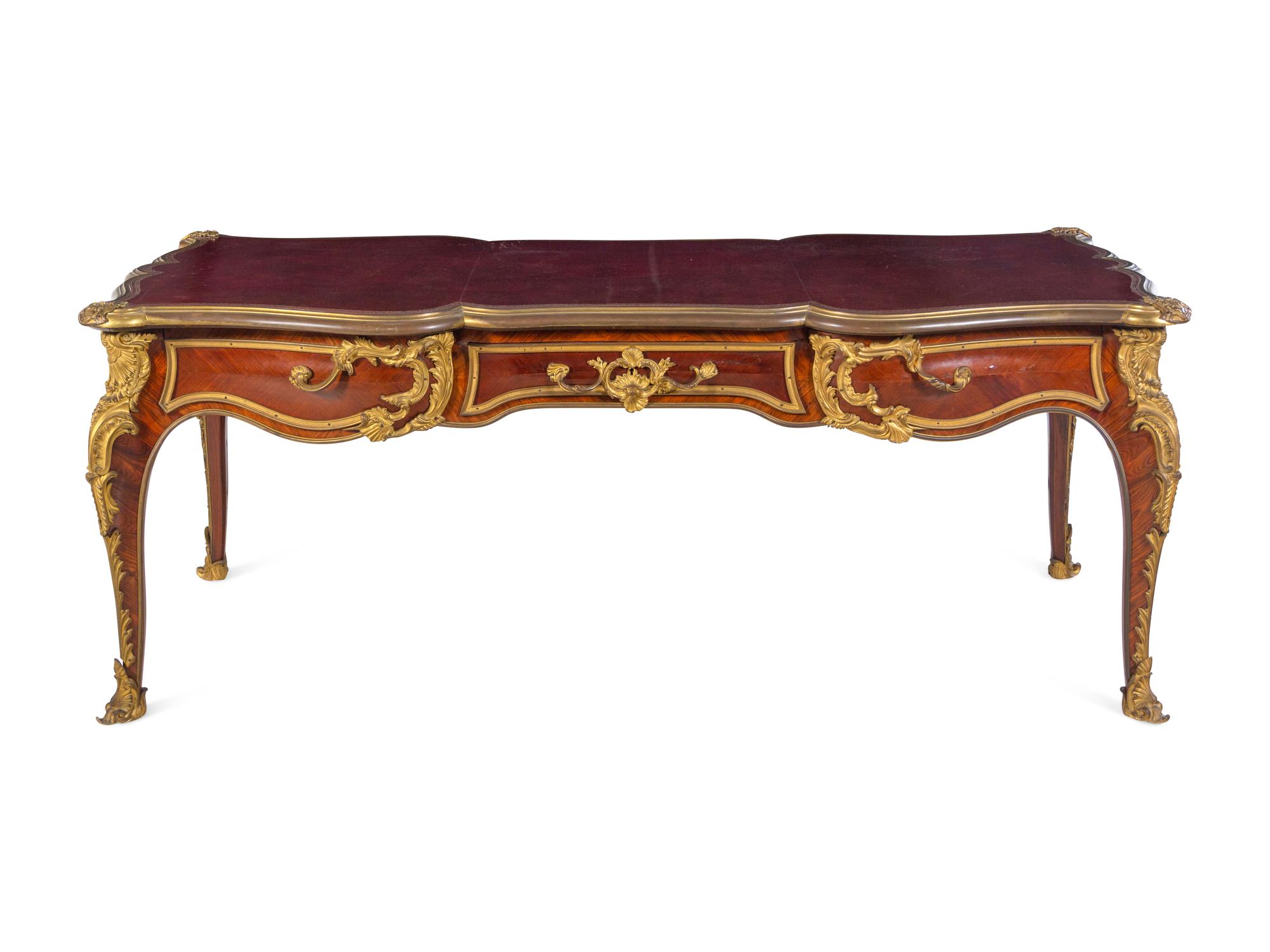 A Louis XV Style Gilt Bronze Mounted and Tooled Leather-Inset Tulipwood Bureau Plat
