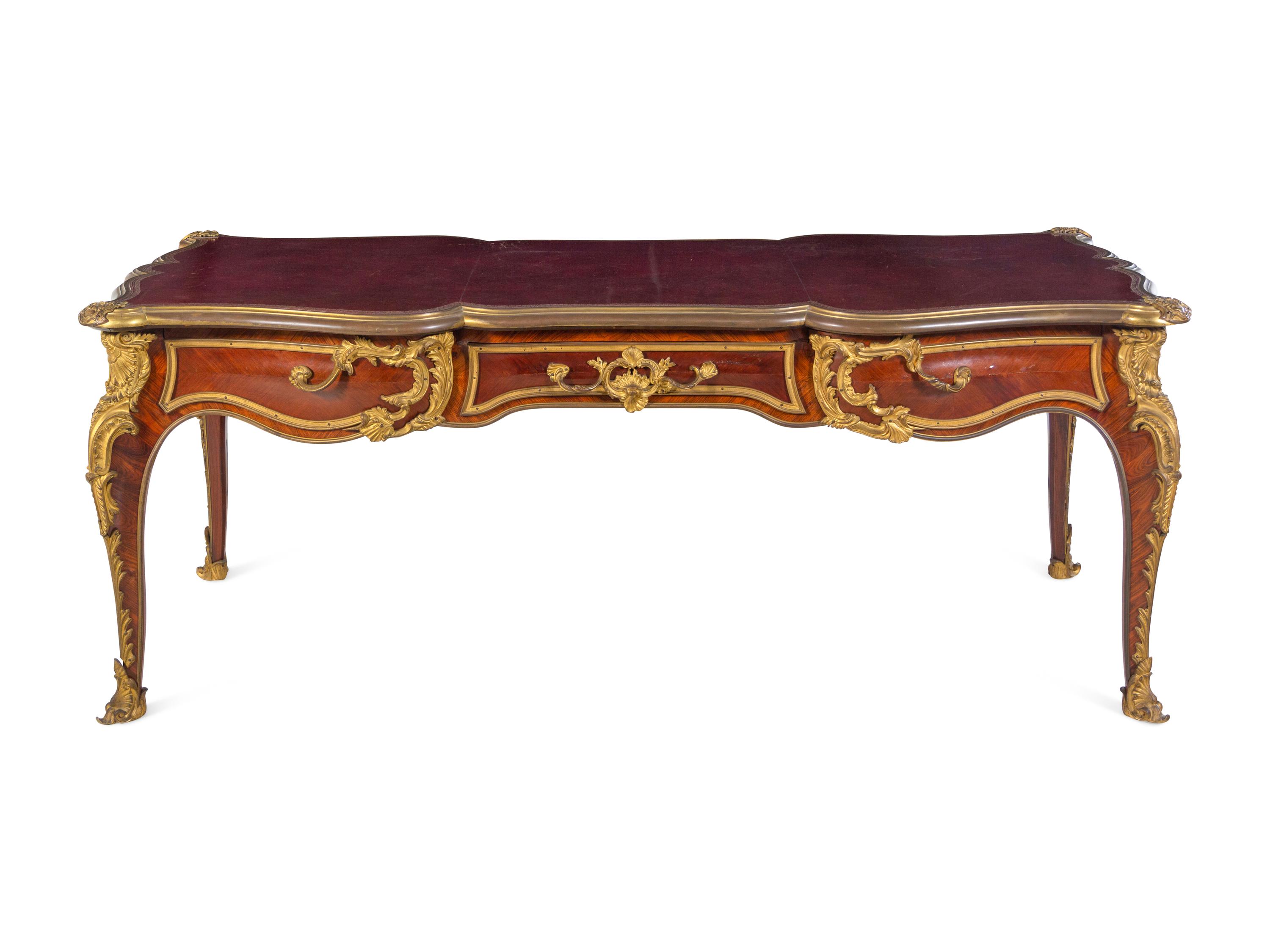 A Louis XV Style Gilt Bronze Mounted and Tooled Leather-Inset Tulipwood Bureau Plat
