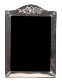 An English Silver Framed Easel Back Mirror, Asprey & Company, having a shaped crest with floral decoration.
