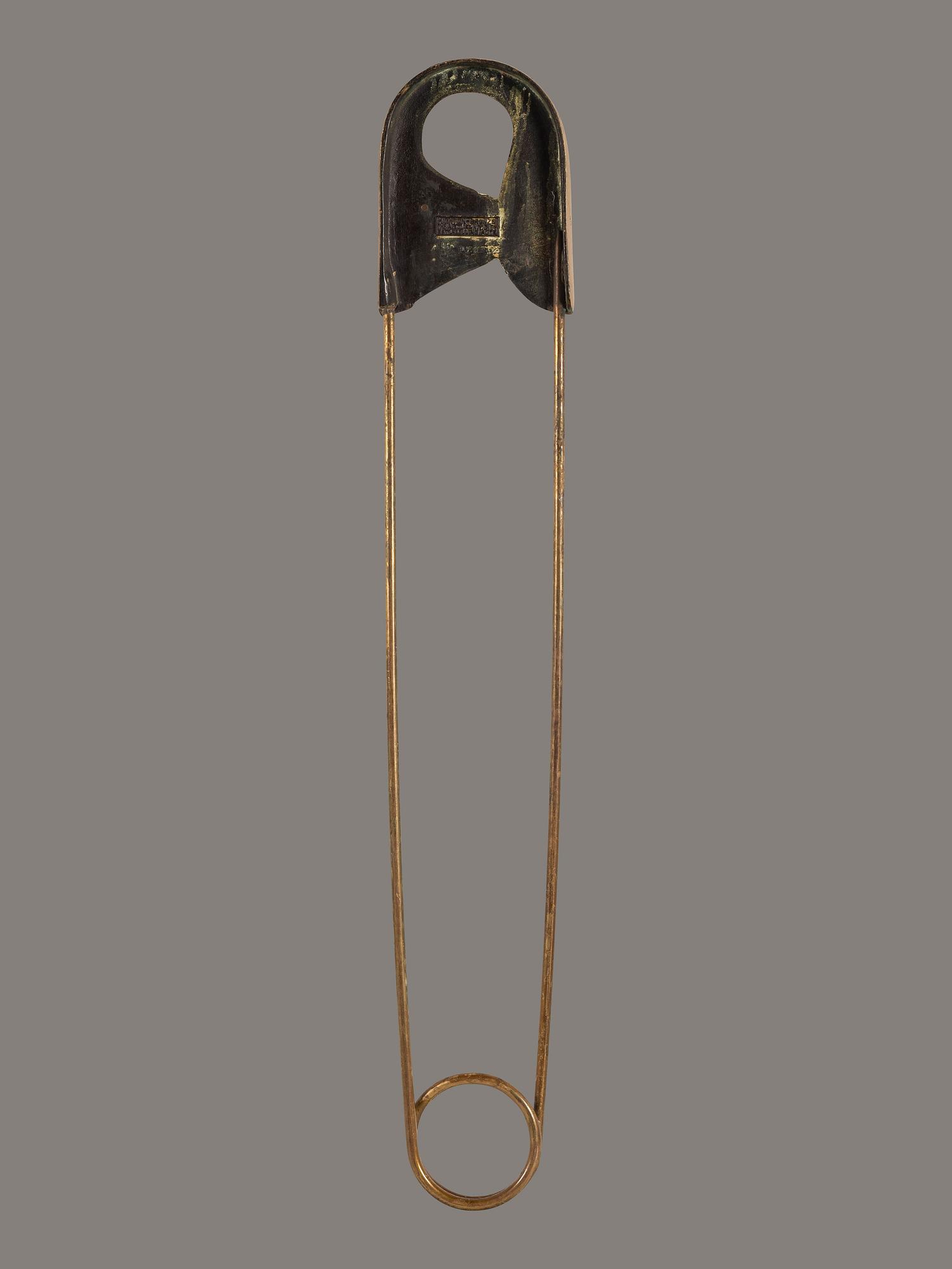 A Gold Painted Bronze Safety Pin Shop Sign