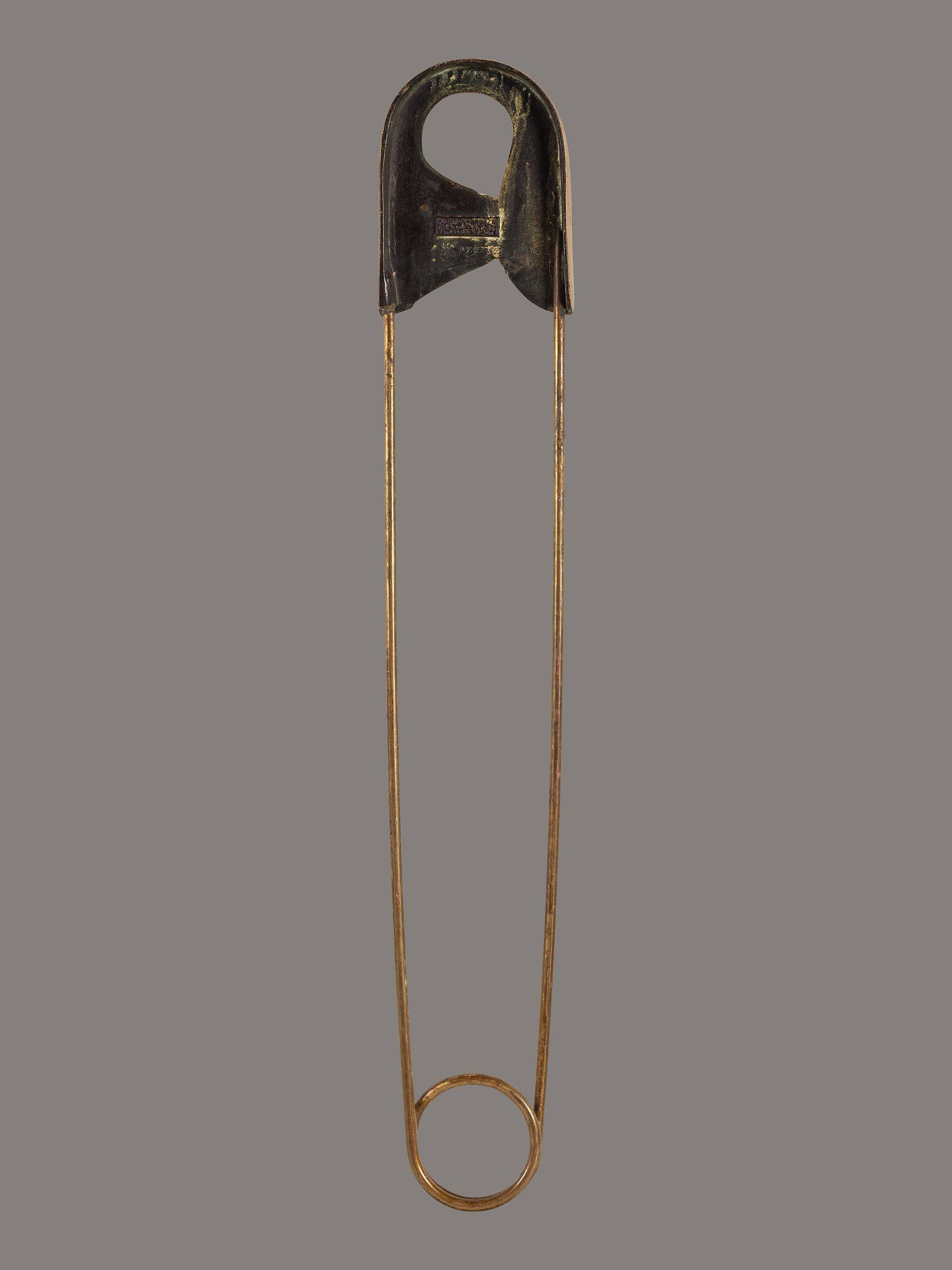 A Gold Painted Bronze Safety Pin Shop Sign