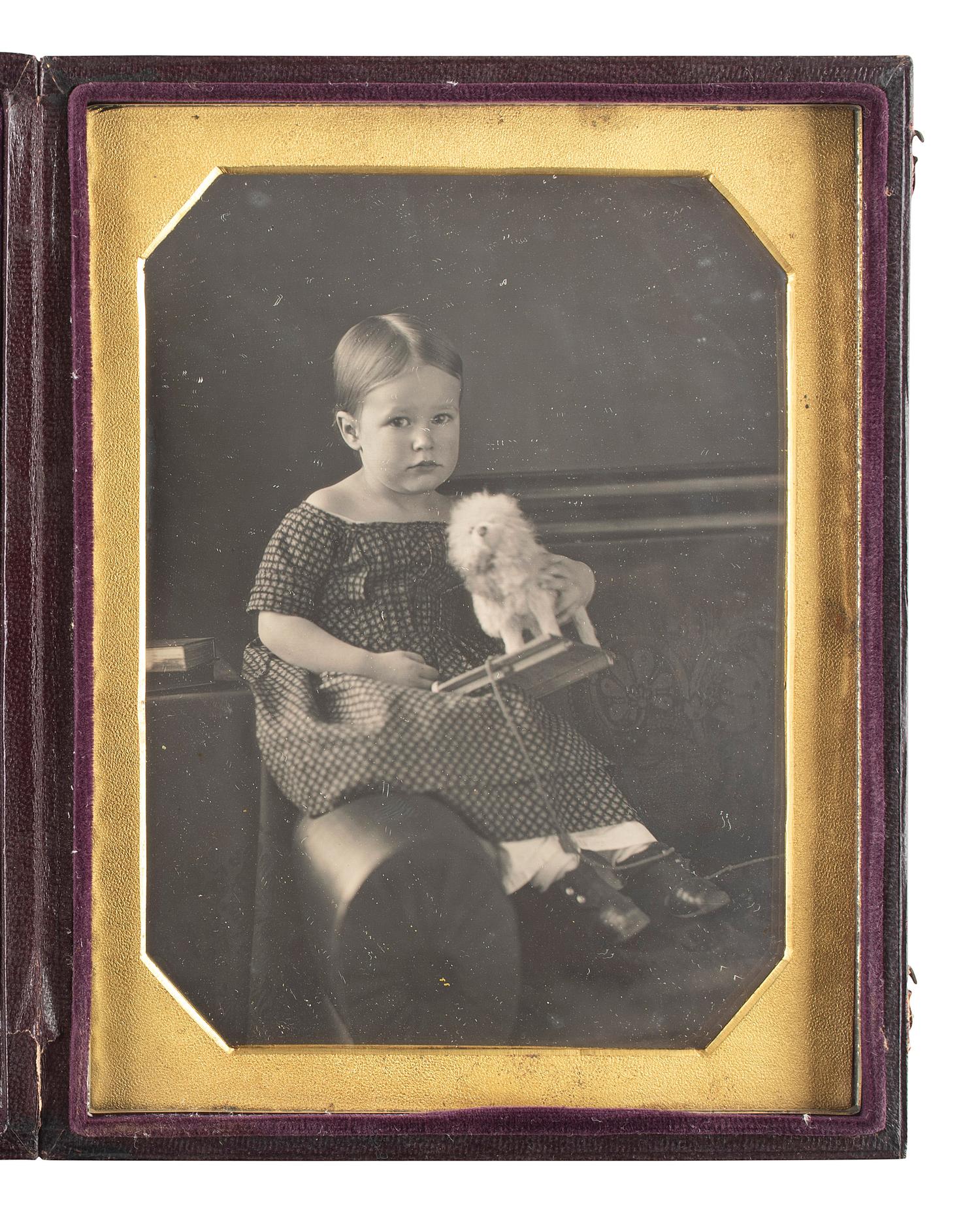 [EARLY PHOTOGRAPHY]. Half plate daguerreotype of a three-year-old girl and her toy dog.