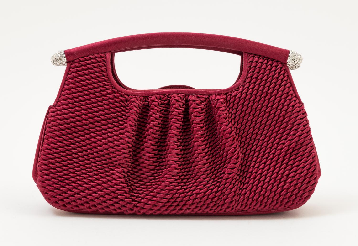 A Judith Leiber Bordeaux Satin Textured Clutch, 8" x 4.5" x 1.5".