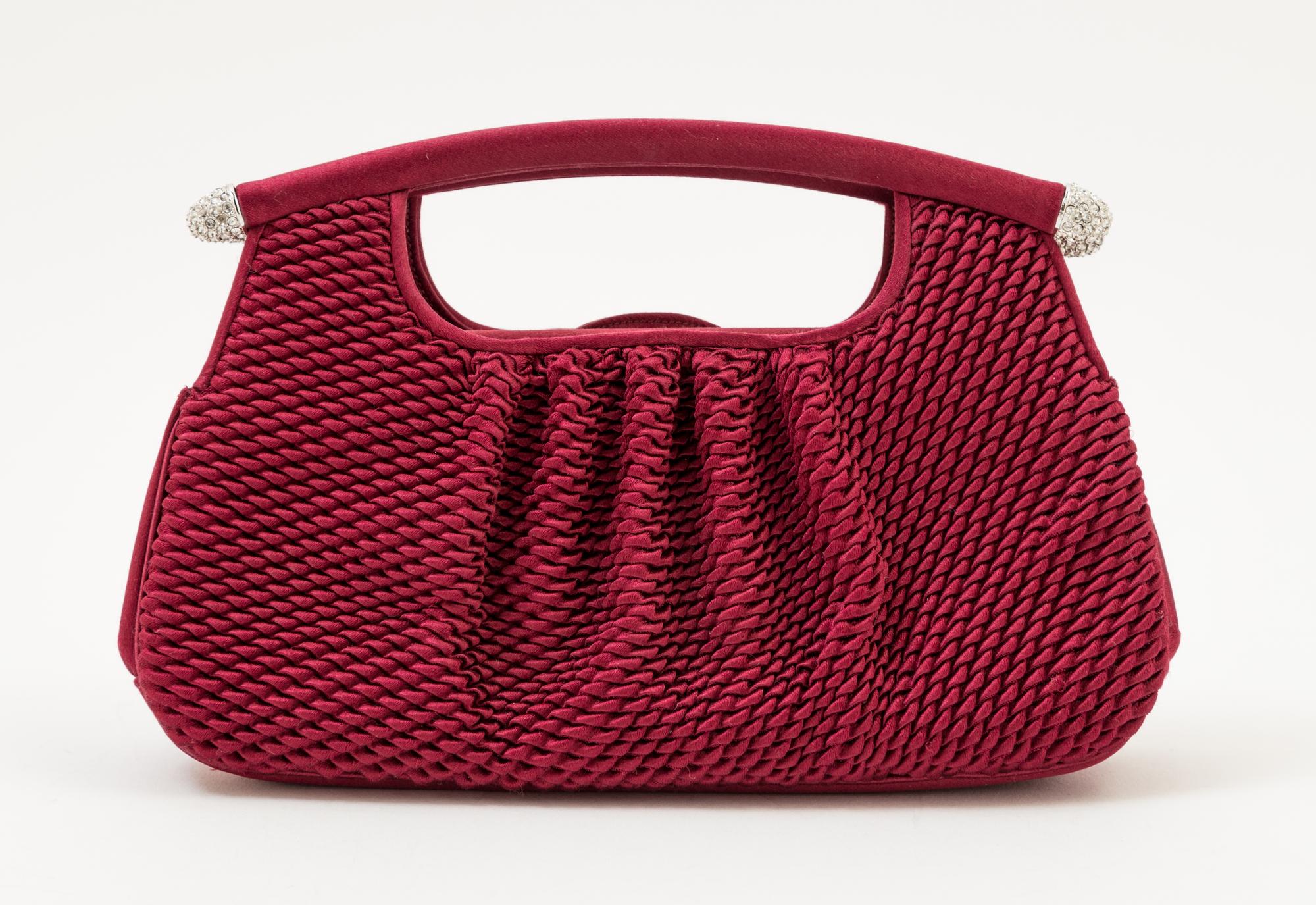 A Judith Leiber Bordeaux Satin Textured Clutch, 8" x 4.5" x 1.5".
