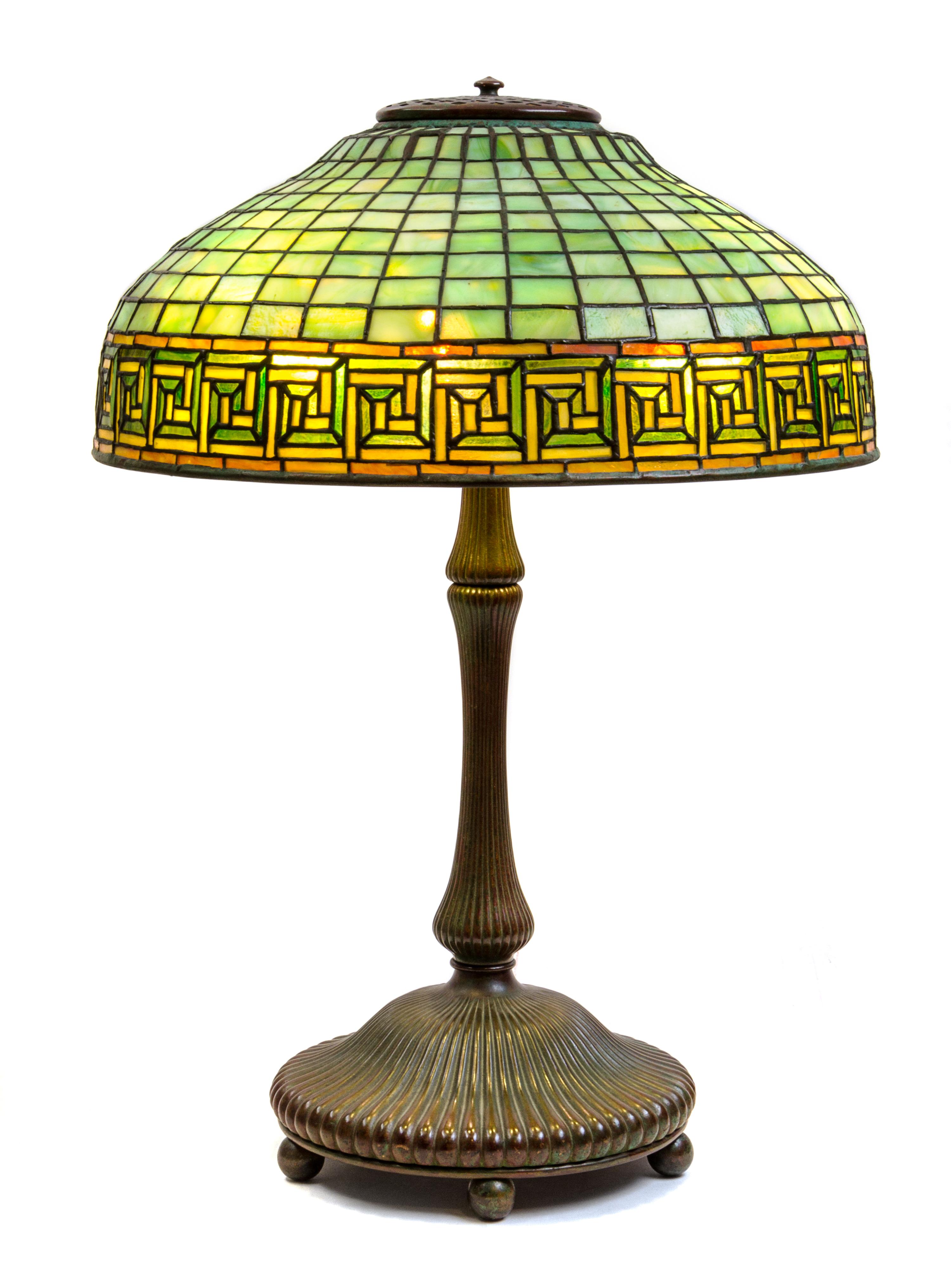 A Tiffany Studios Leaded Favrile Glass and Bronze Greek Key Table Lamp Height 23 x diameter of shade 16 inches.