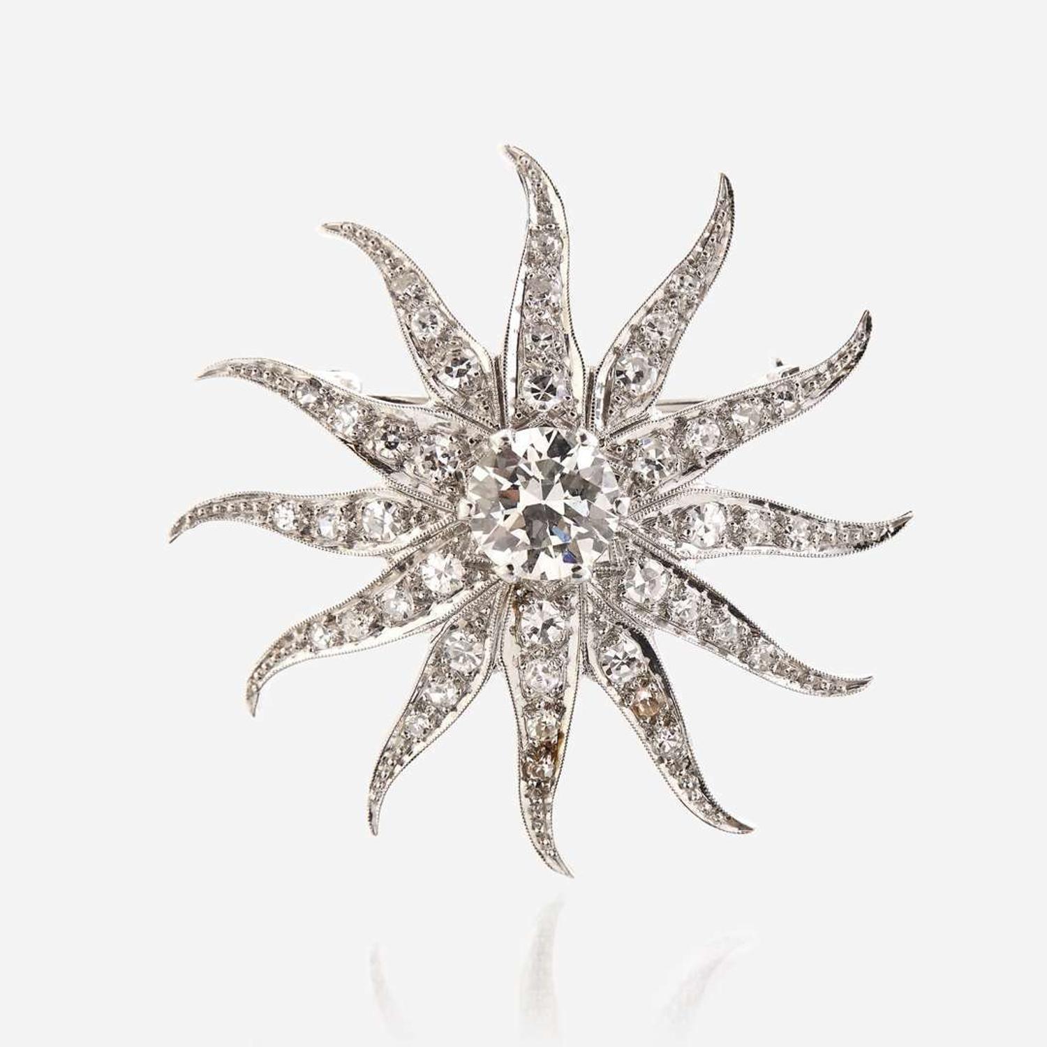A diamond and fourteen karat white gold pendant/brooch