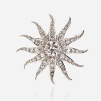 A diamond and fourteen karat white gold pendant/brooch