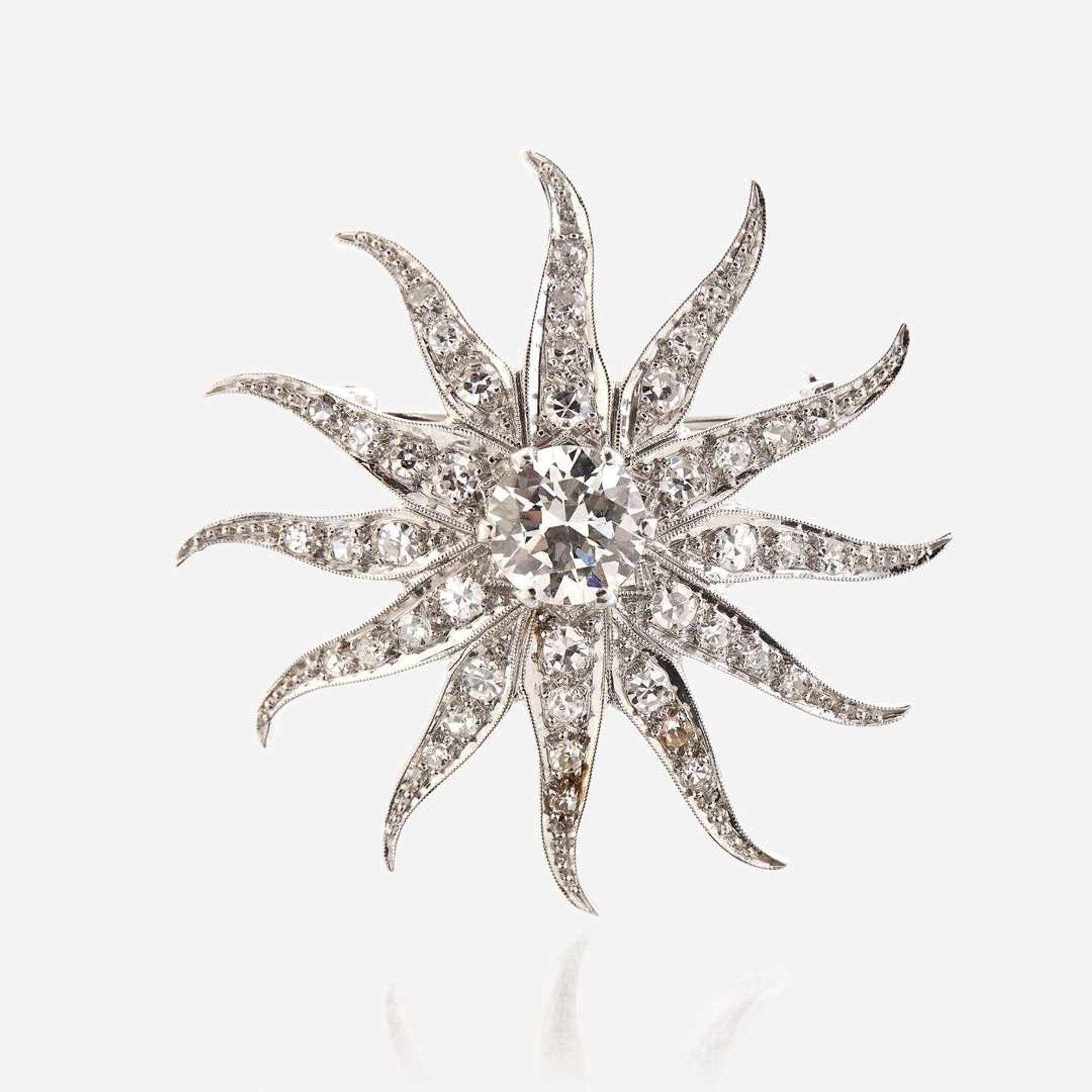 A diamond and fourteen karat white gold pendant/brooch