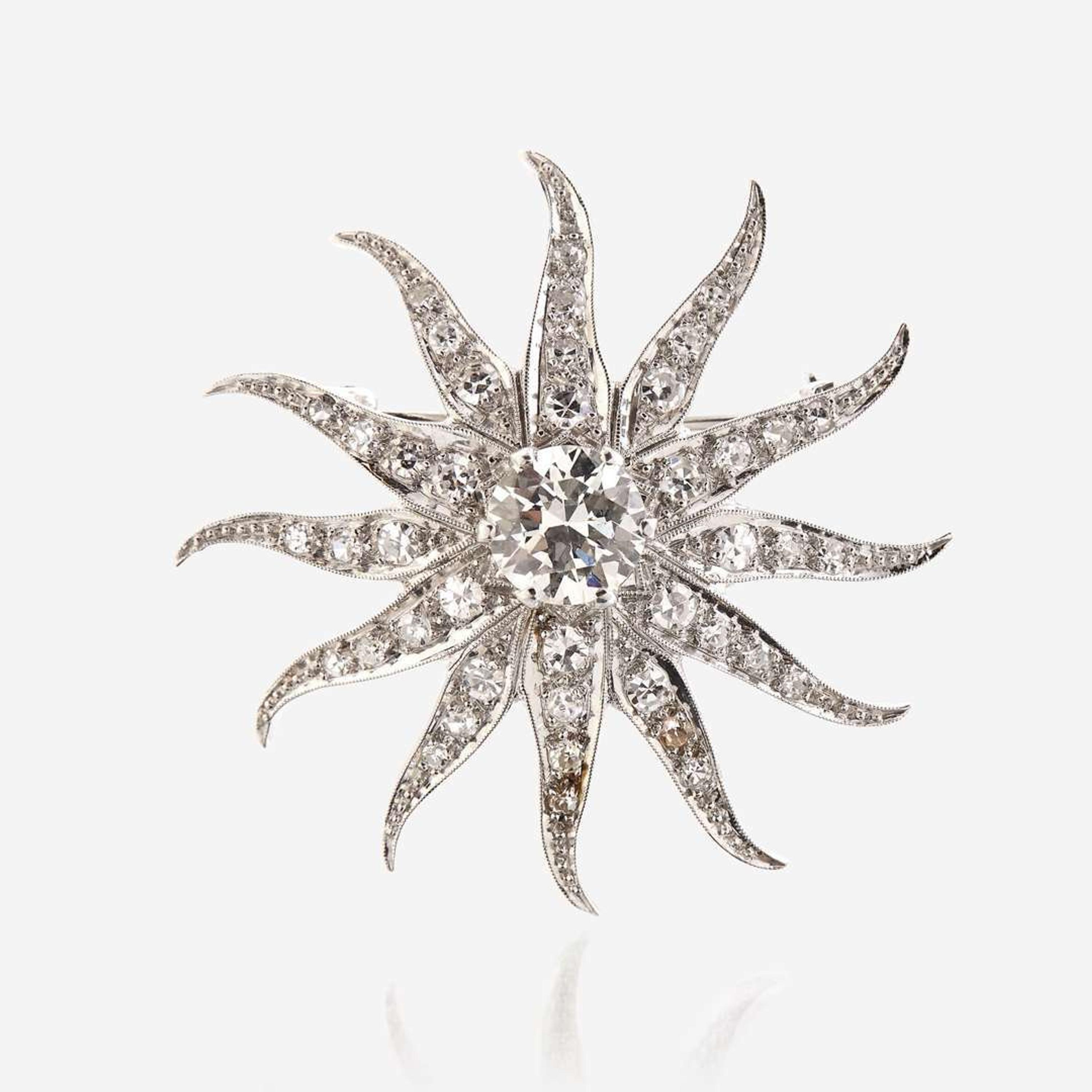 A diamond and fourteen karat white gold pendant/brooch