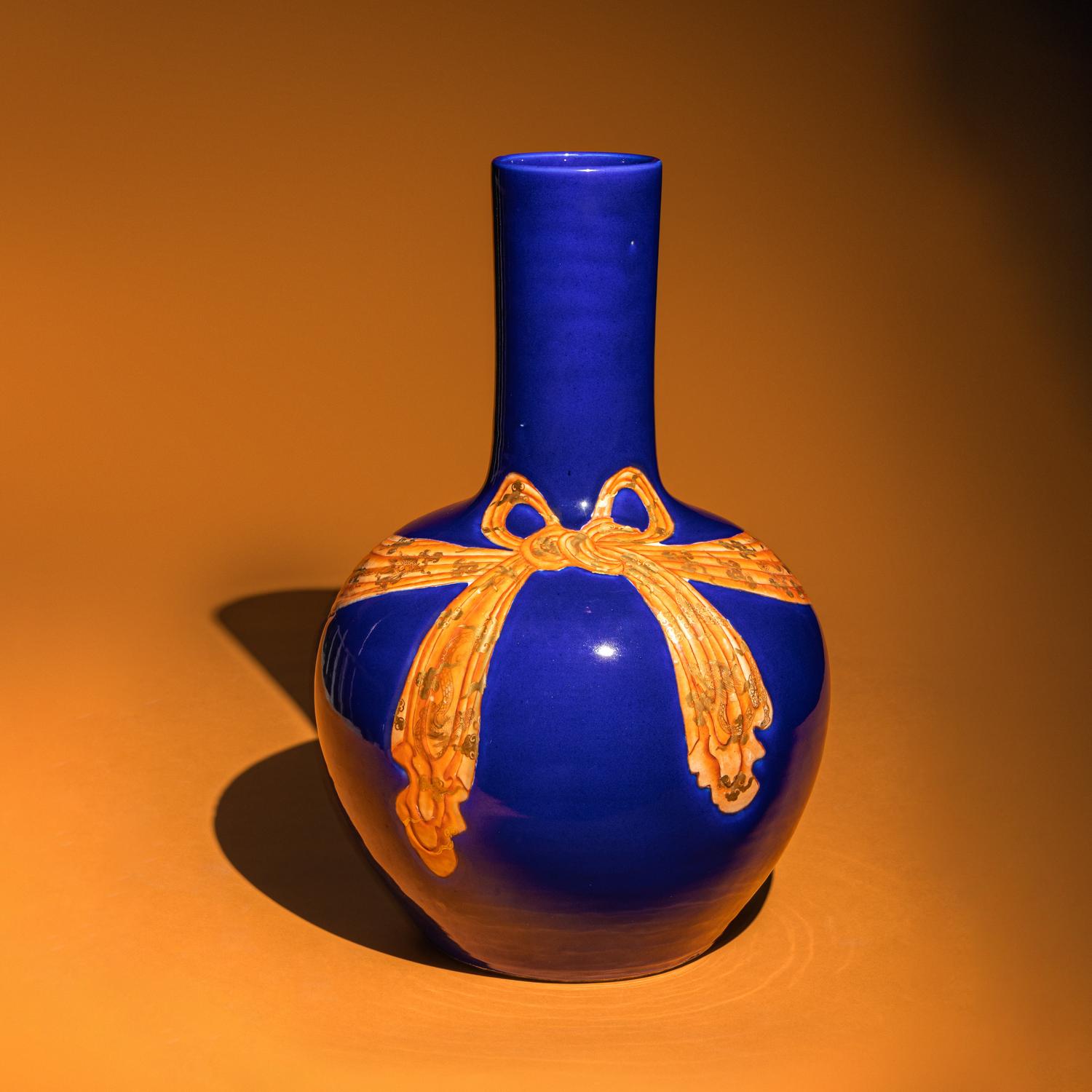 A Large Chinese Gilt and Iron Red Highlighted Blue Glazed Porcelain 'Ribbon-Tied' Vase, Tianqiuping, Late Qing Dynasty/Early Republic Period 晚清/民國 藍地描金包袱式天球瓶
