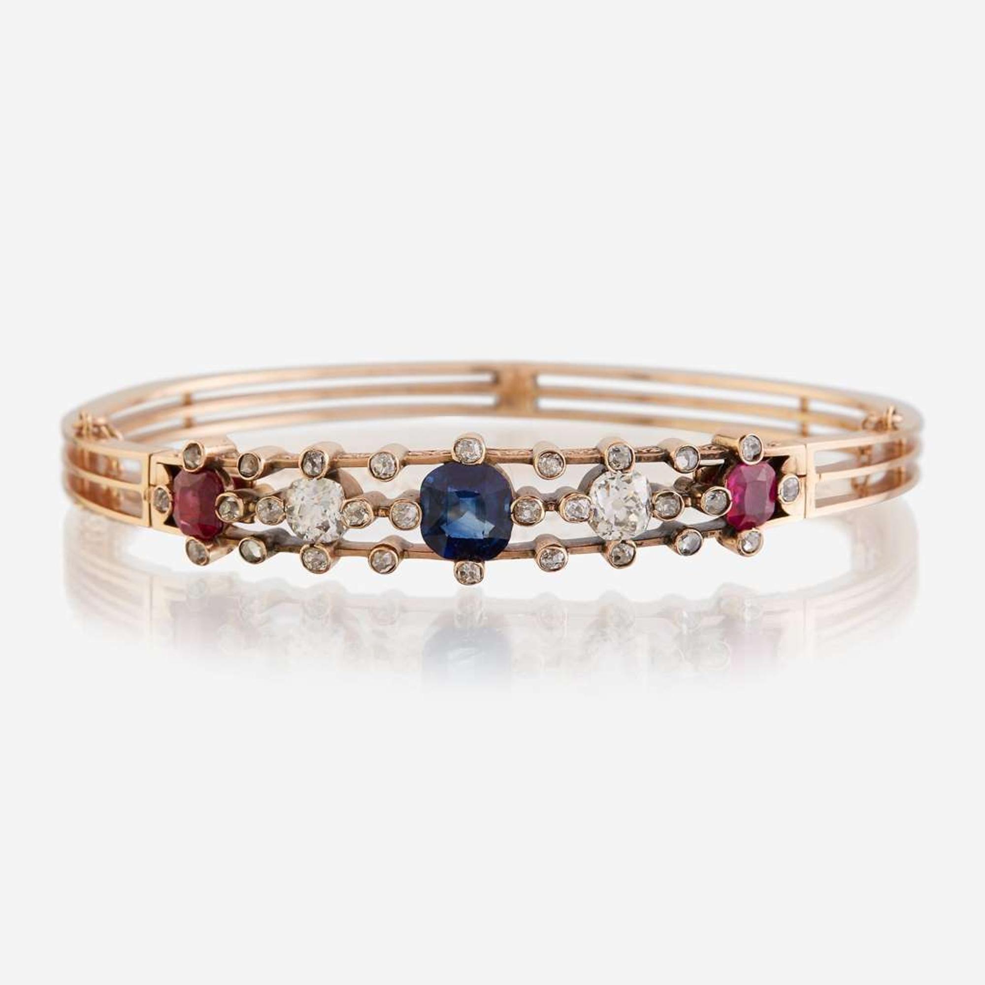 An antique fourteen karat rose gold, diamond, sapphire, and ruby bangle
