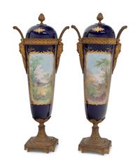 A Pair of Sèvres Style Gilt Bronze Mounted Porcelain Urns