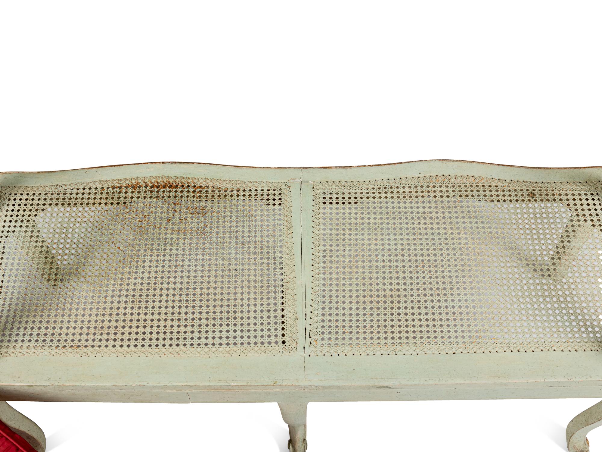A Pair of Louis XV Green-Painted and Parcel-Gilt Cane Seat Window Benches