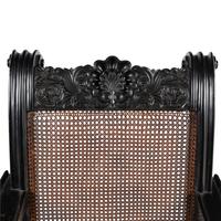 An Anglo-Colonial Carved Ebony and Caned Armchair