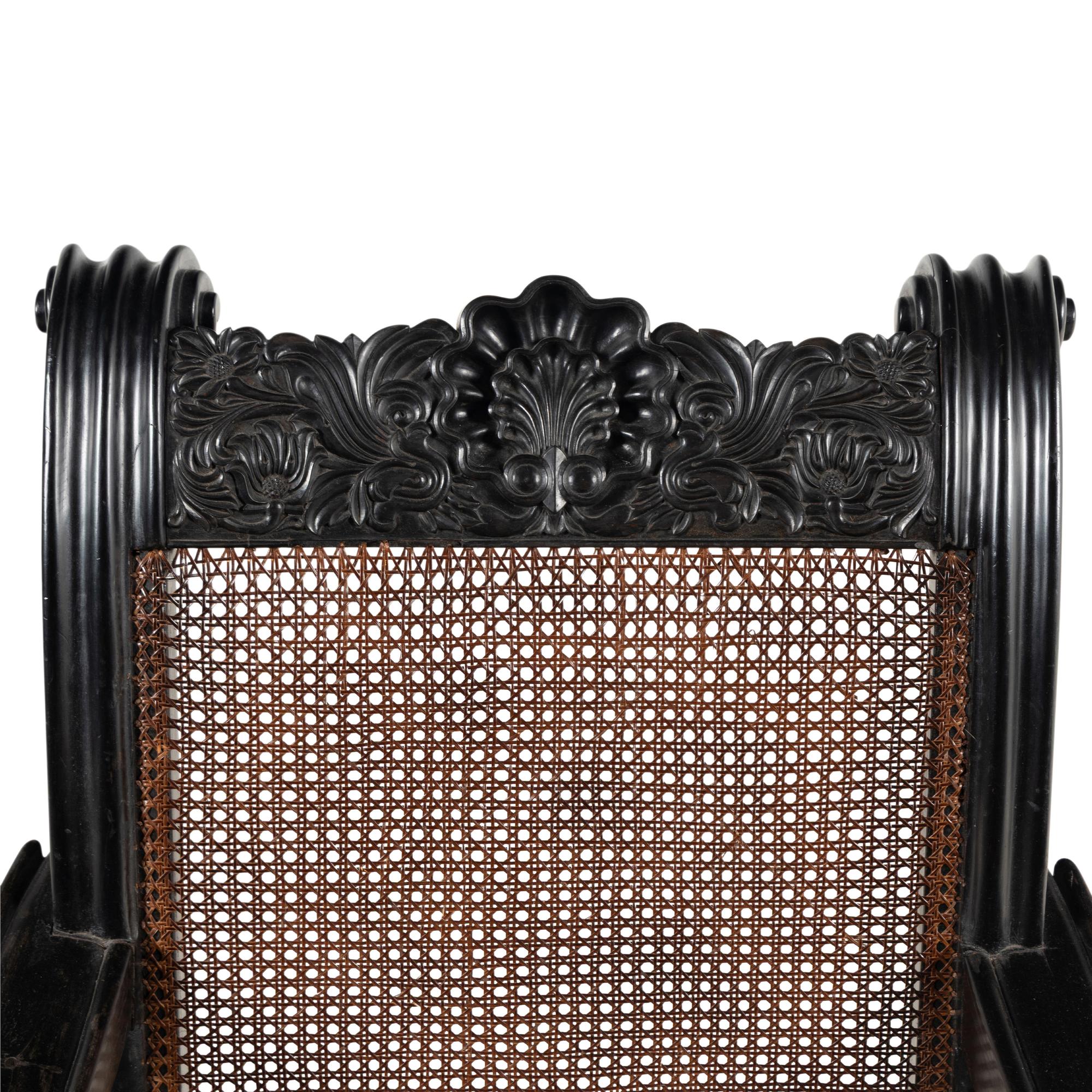 An Anglo-Colonial Carved Ebony and Caned Armchair
