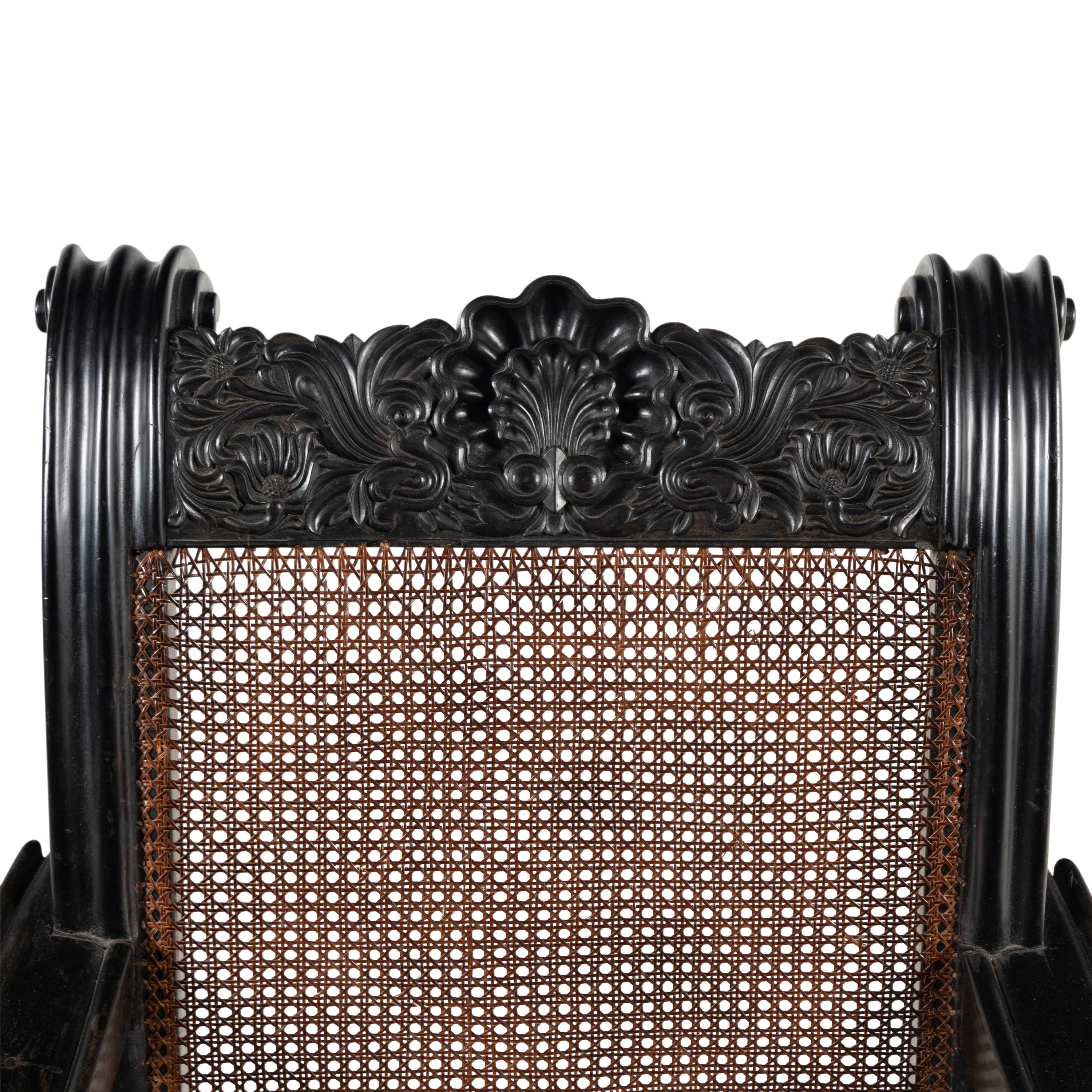 An Anglo-Colonial Carved Ebony and Caned Armchair