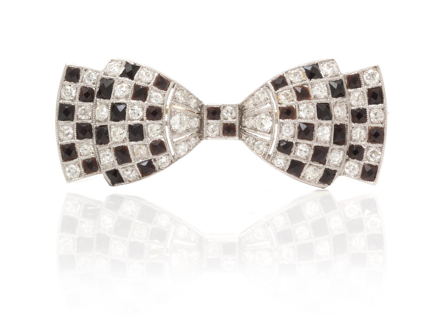 An Art Deco Platinum, Diamond and Onyx Bow Brooch, 3.70 dwts.