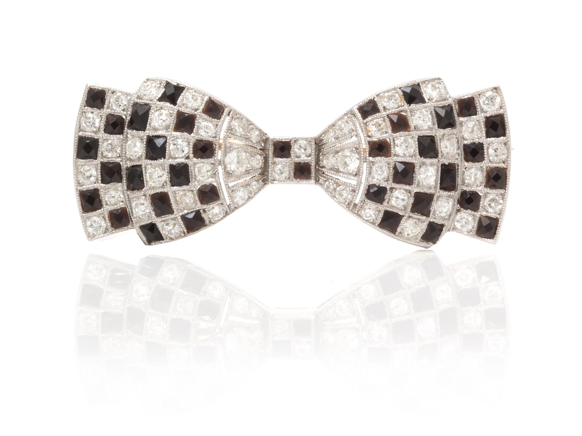 An Art Deco Platinum, Diamond and Onyx Bow Brooch, 3.70 dwts.