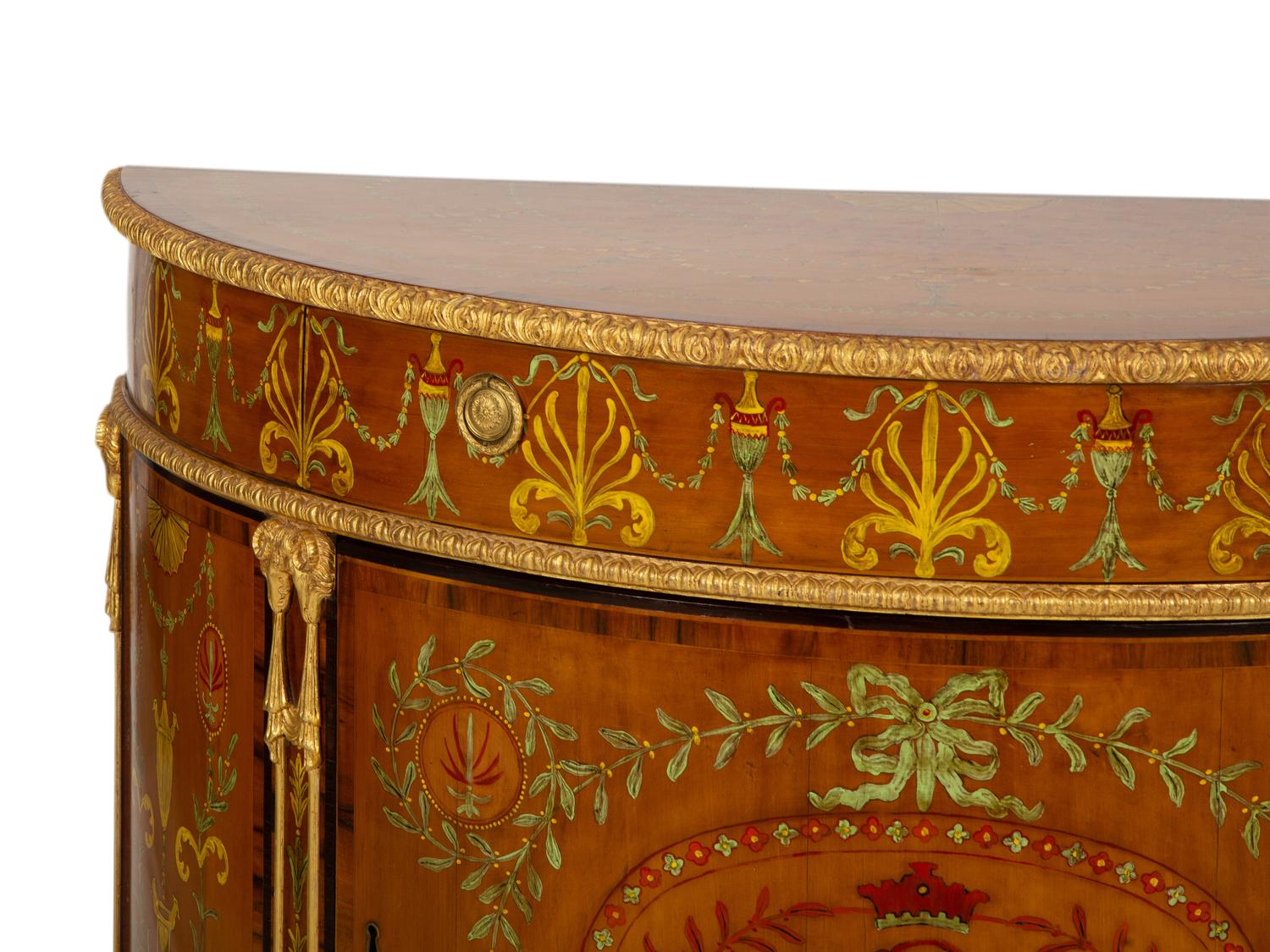 A Pair of Adam Style Painted Parcel Gilt and Marquetry Inlaid Demilune Commodes