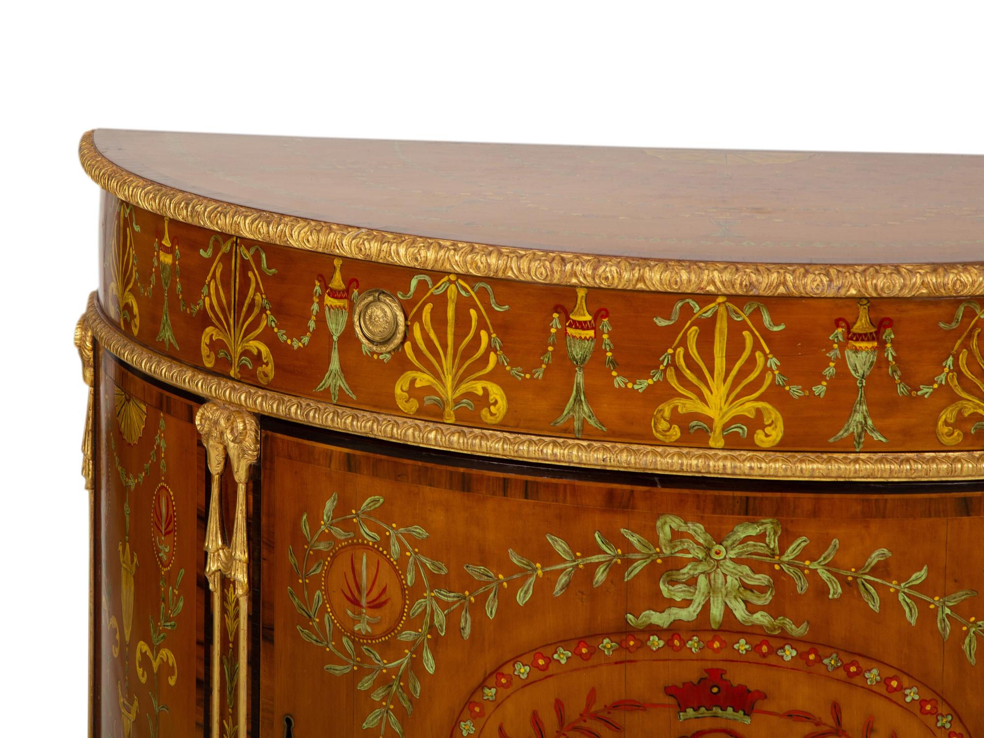 A Pair of Adam Style Painted Parcel Gilt and Marquetry Inlaid Demilune Commodes