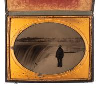 [EARLY PHOTOGRAPHY]. LAWRENCE, Martin M., photographer. Whole plate ambrotype of a man posed in front of Niagara Falls. New York, NY: ca 1853-1860.