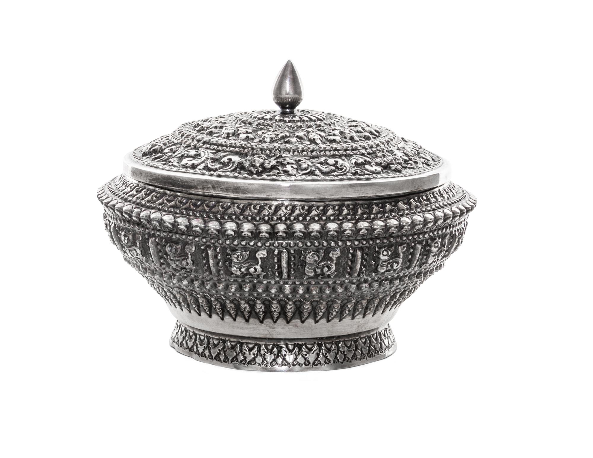 A Silver Box and Cover, Probably Thai, 20th Century, of circular form with allover repeating relief decoration.