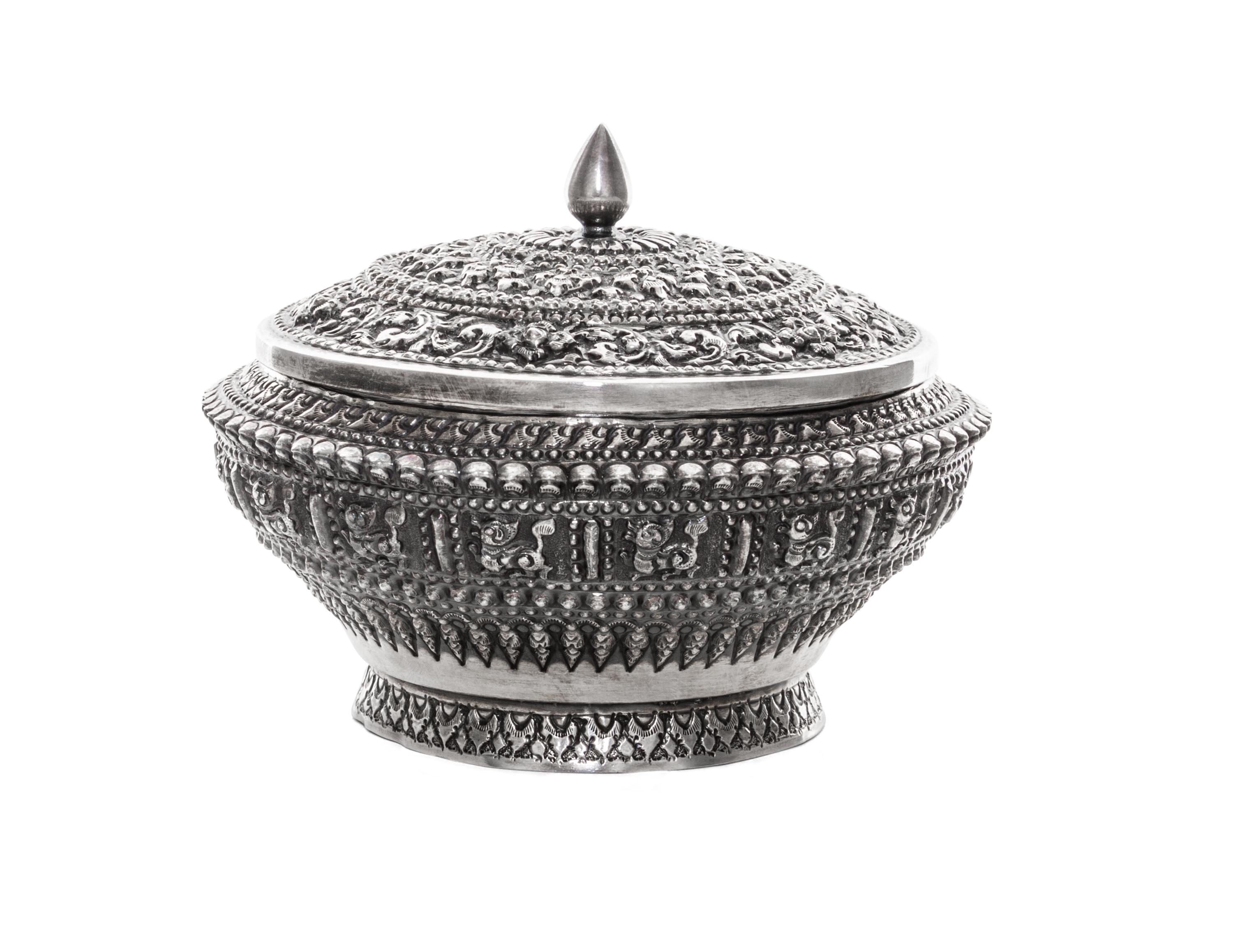 A Silver Box and Cover, Probably Thai, 20th Century, of circular form with allover repeating relief decoration.