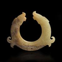 A finely carved Chinese beige and brown jade circular pendant 玉佩一件