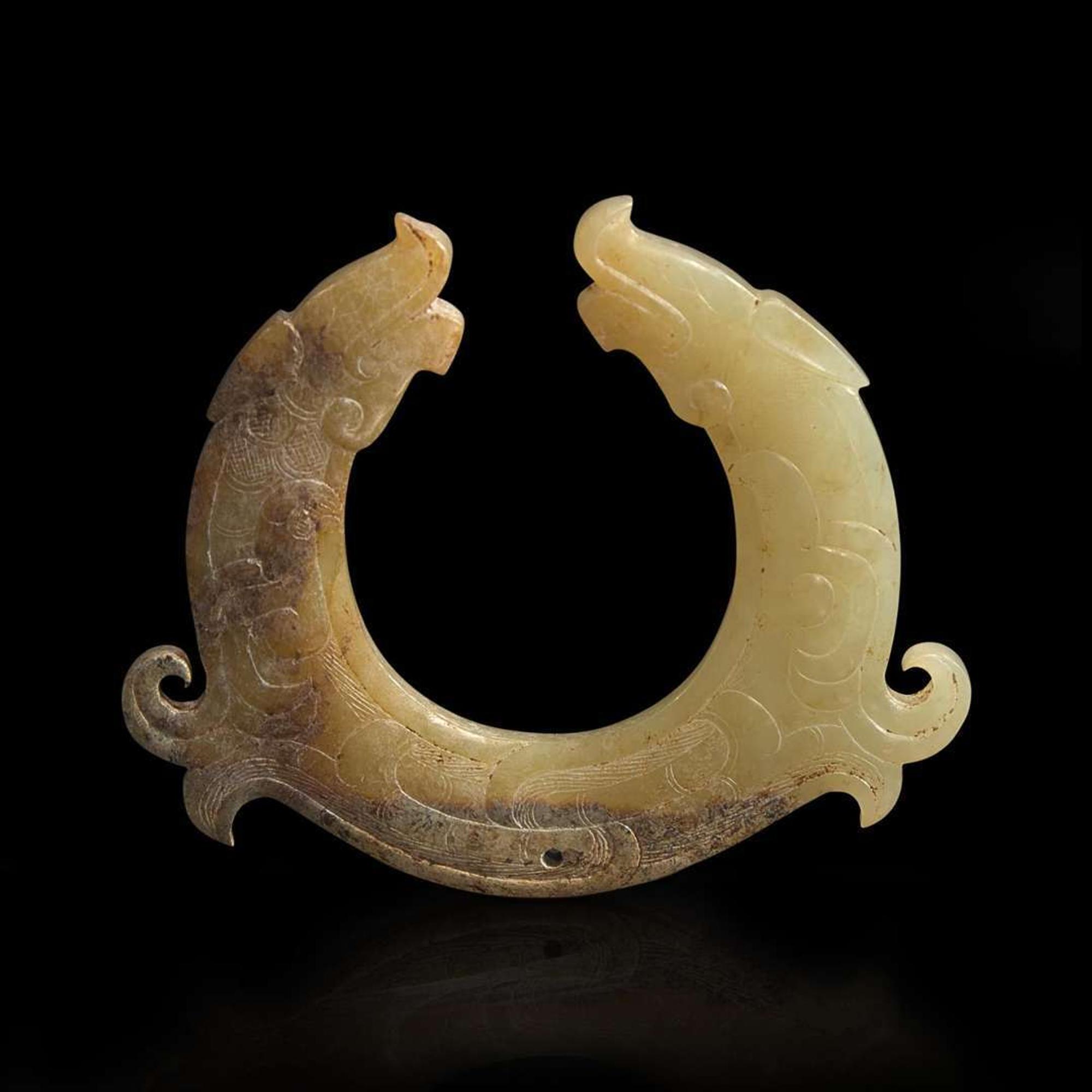 A finely carved Chinese beige and brown jade circular pendant 玉佩一件