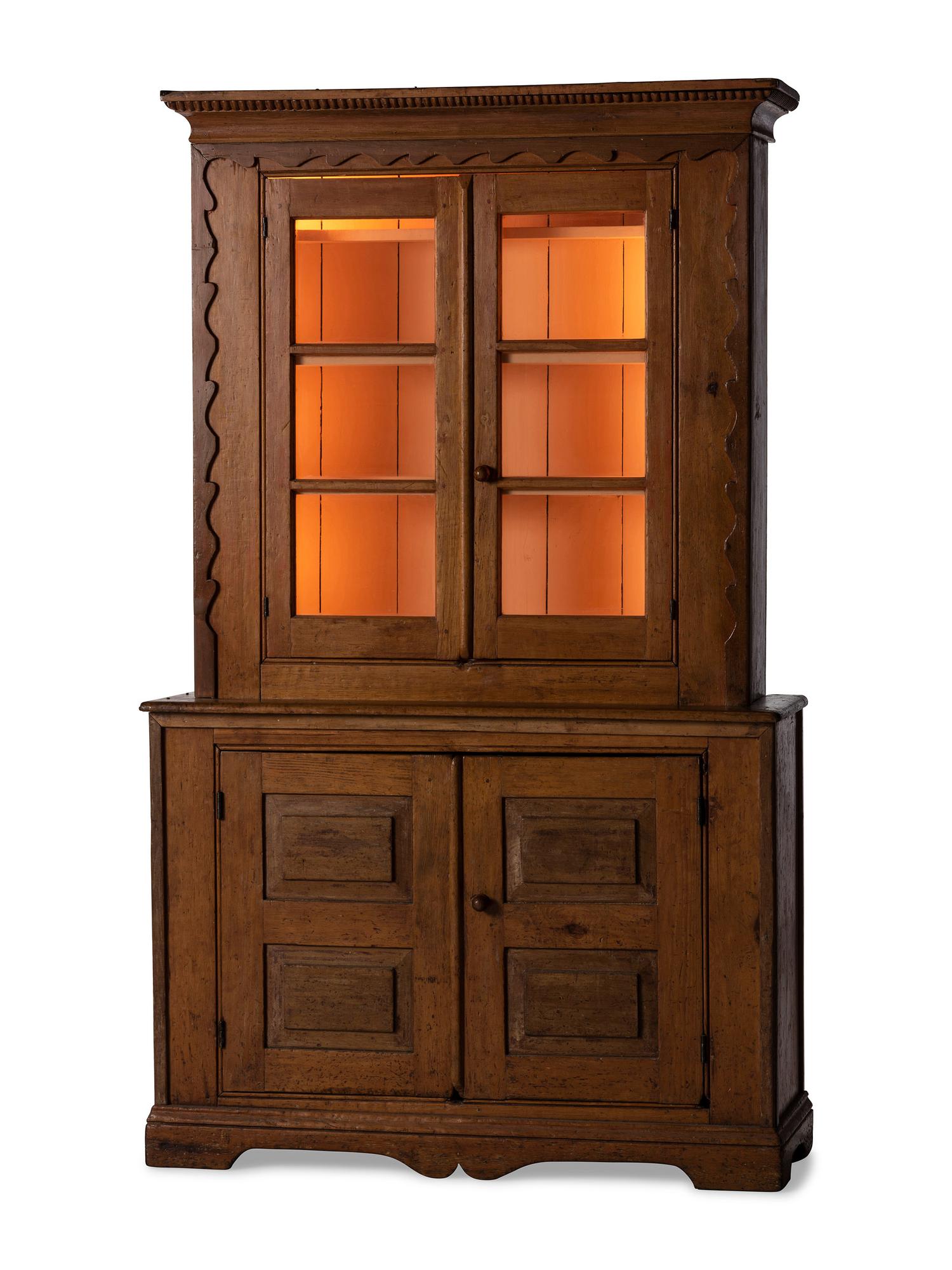 A Folk Art Carved and Paneled Pine Step-Back Cupboard