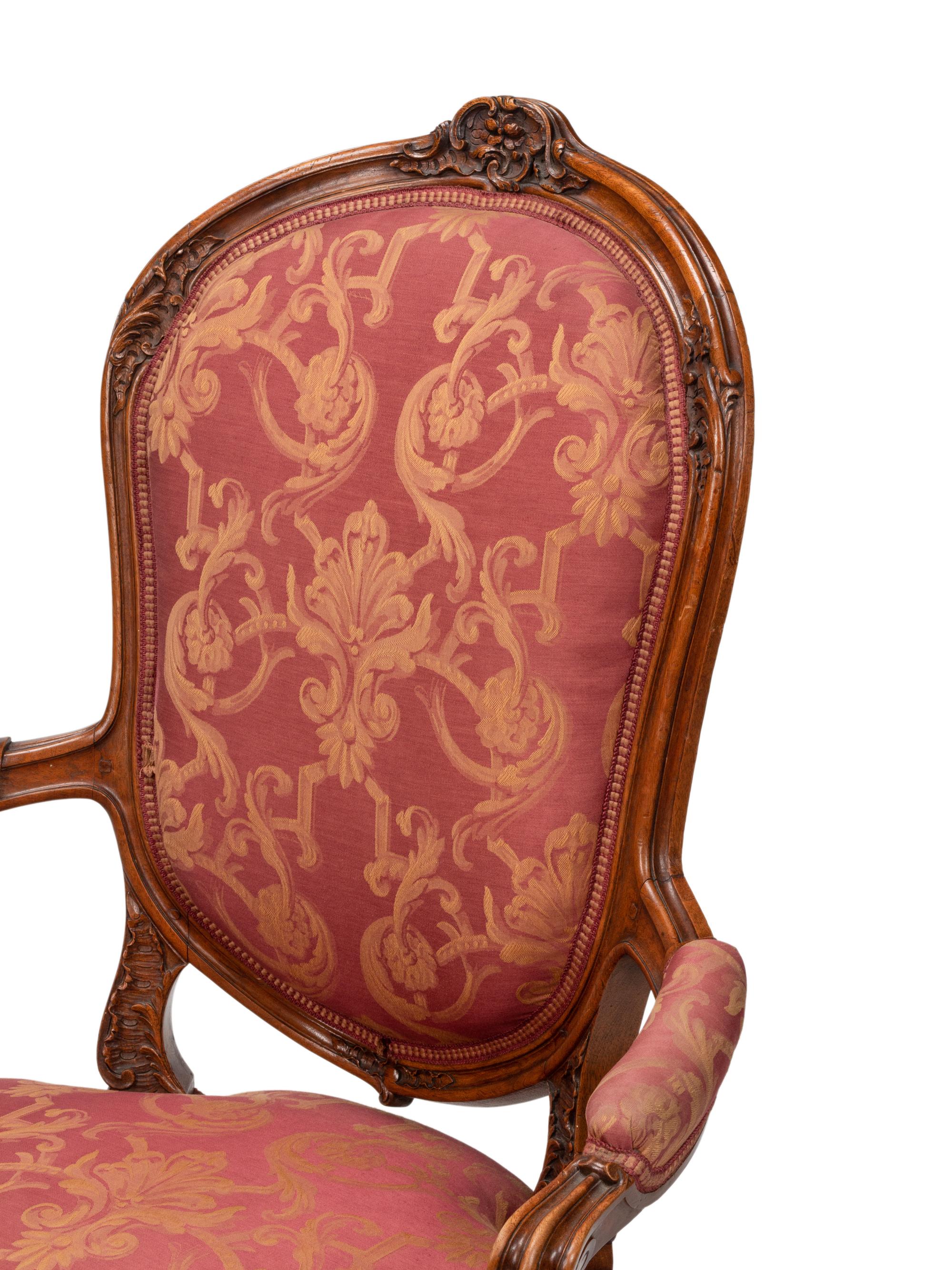 A Pair of Louis XV Style Carved Walnut Fauteuils