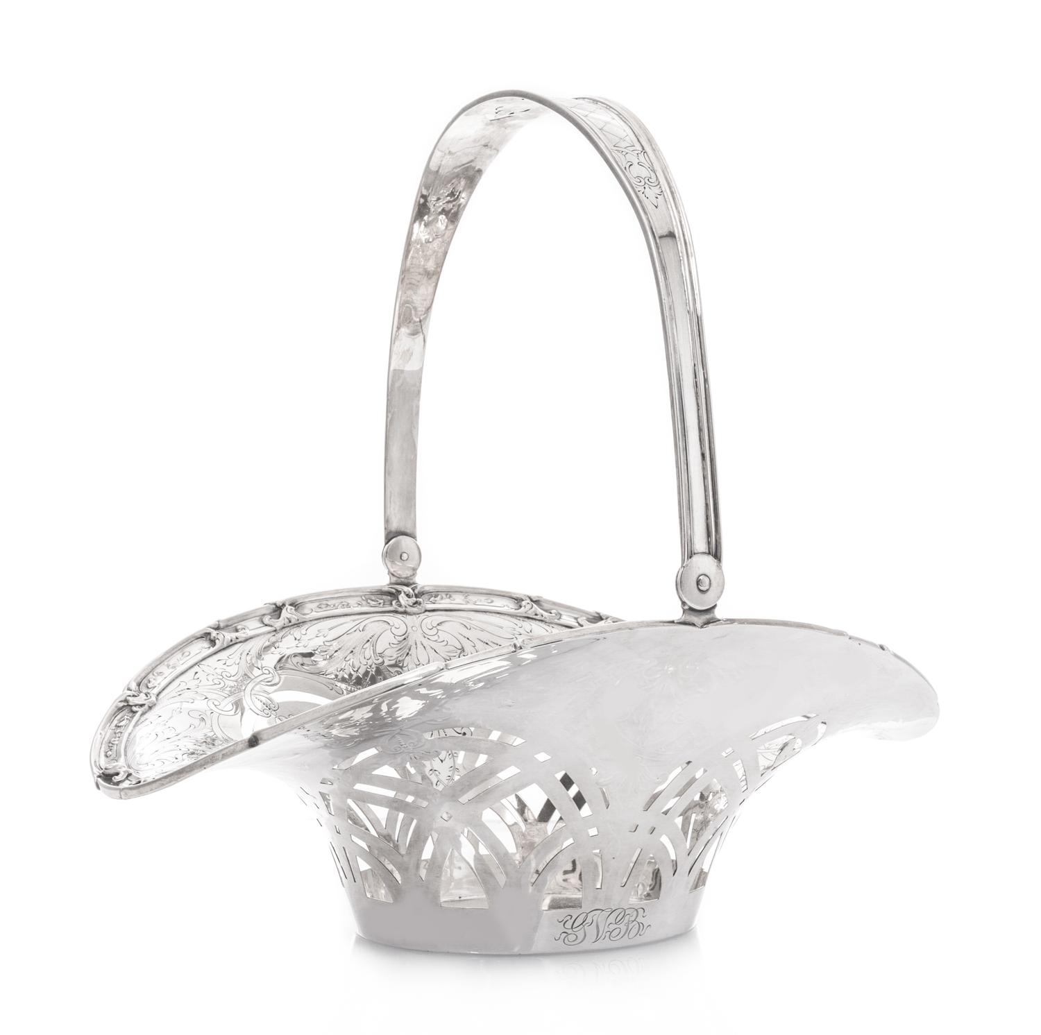 An American Silver Fruit Basket, Grogan Company, Pittsburgh, PA, with a swing handle, pierced sides and engraved foliate scrolls.